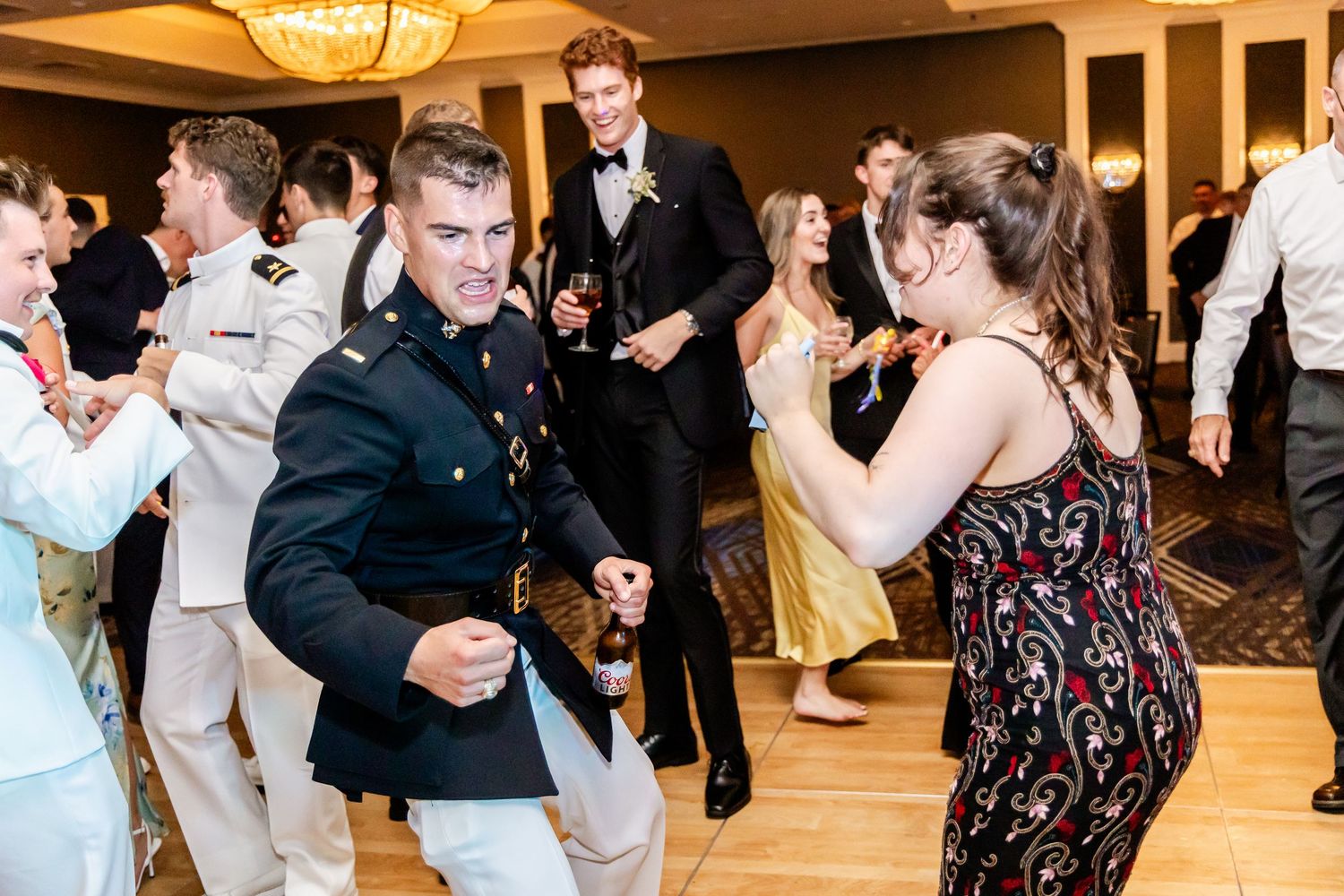 Guests dancing and celebrating at an elegant wedding reception with warm lighting.