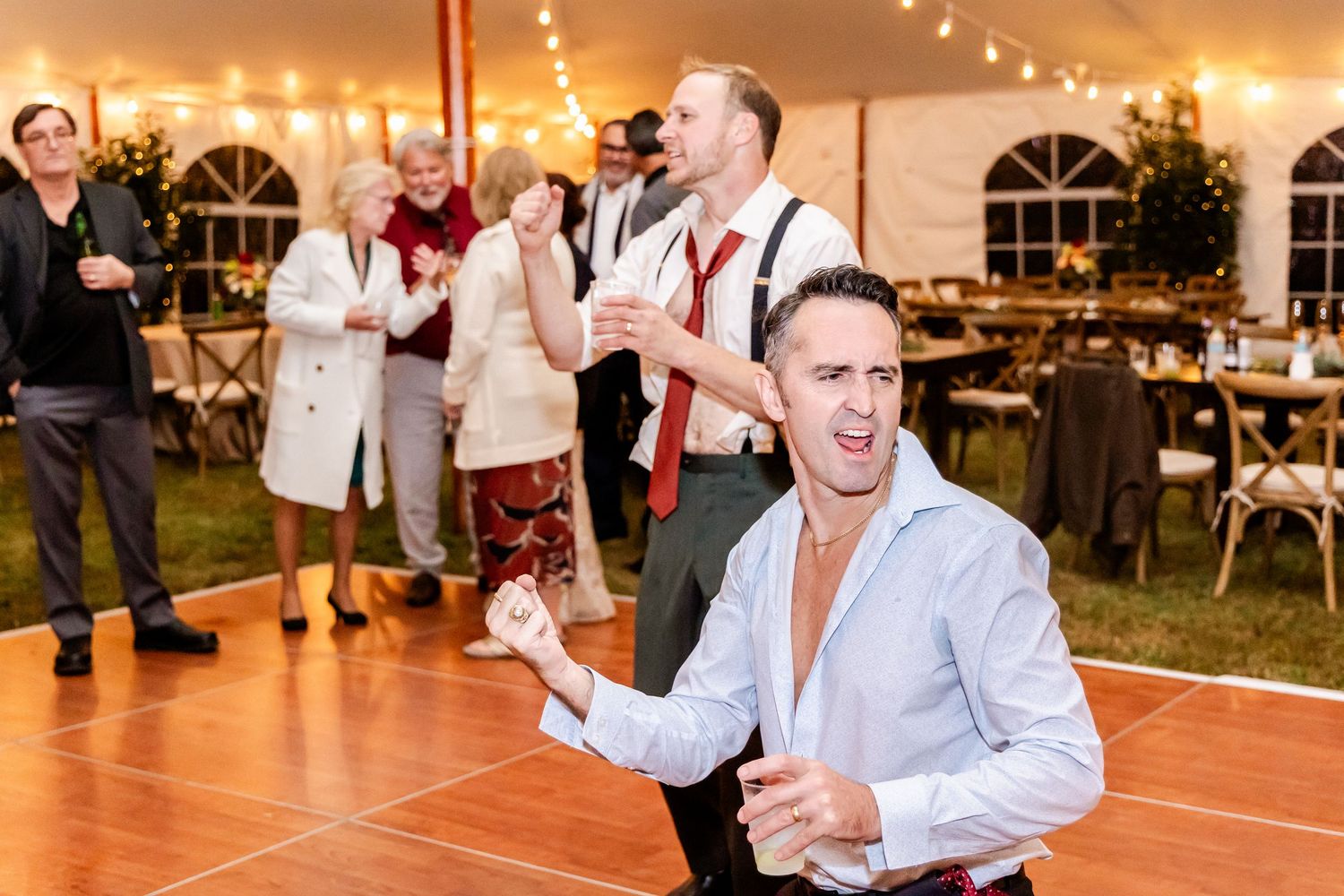 Wedding celebration with guests dancing and enjoying themselves on a warmly lit dance floor.