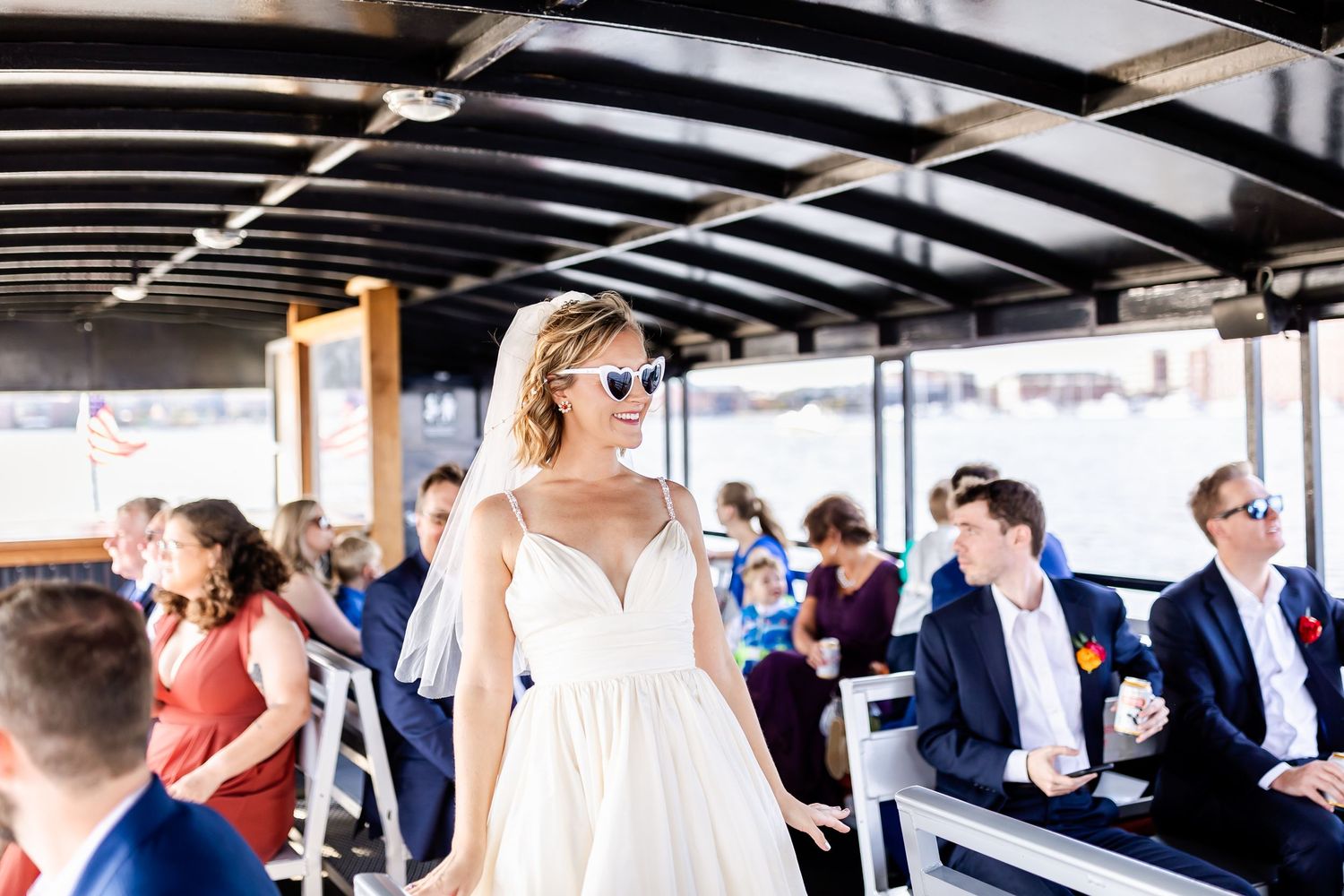 Wedding celebration aboard a boat with guests gathered under covered deck.