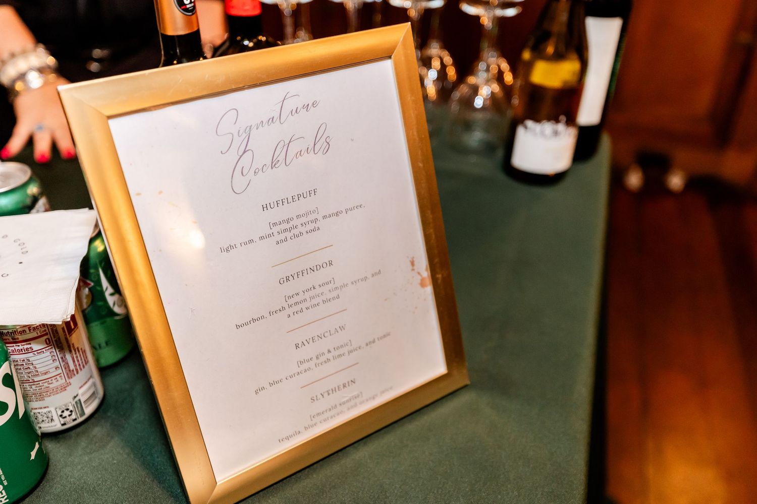 Elegant framed wedding menu displayed on dark green tablecloth.