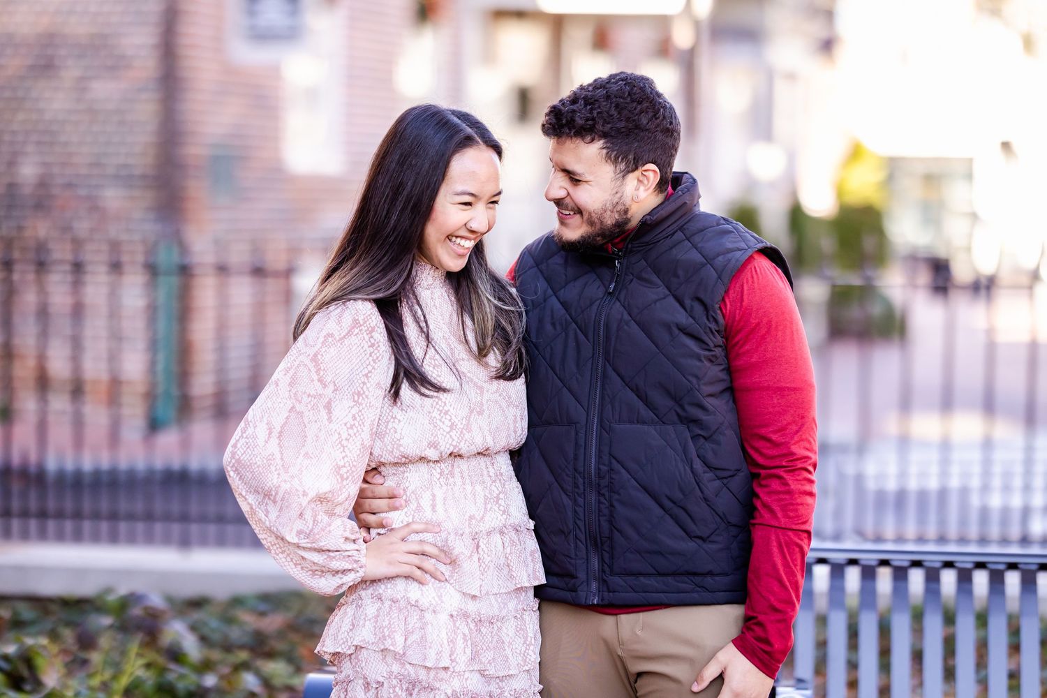 Happy couple sharing a candid moment while laughing together outdoors.