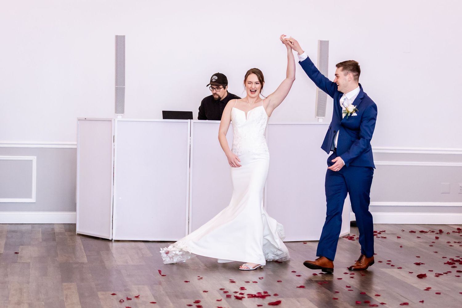Wedding couple and guests dance together during lively reception celebration.