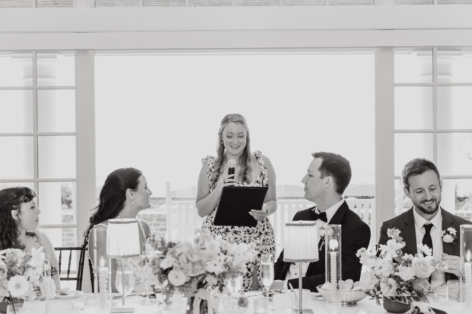 Black and white photo of an elegant wedding reception with tables set for dining.