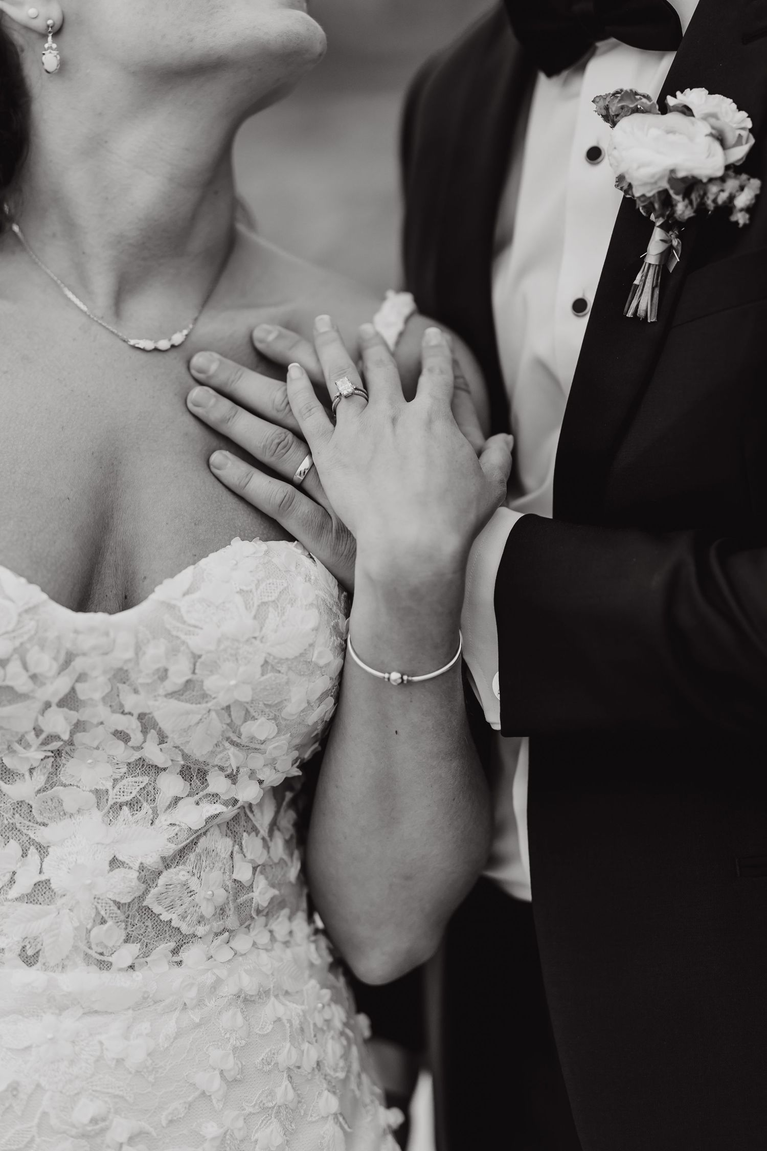 Black and white close-up photos showing hands with wedding rings and formal attire details at a ceremony.