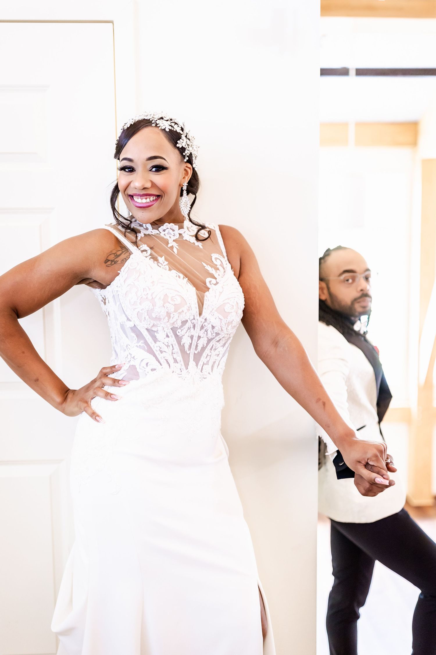 An elegant white wedding dress with intricate lace detailing is captured in a bright studio setting.