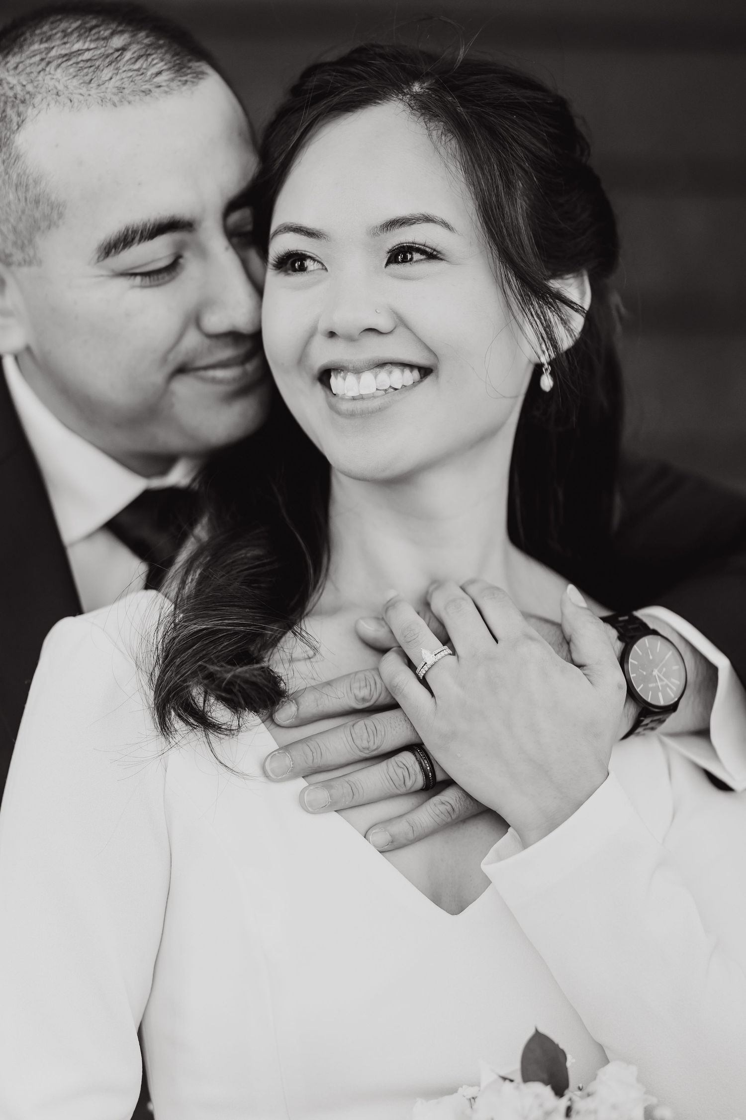 Black and white romantic wedding portrait capturing a tender moment between newlyweds.