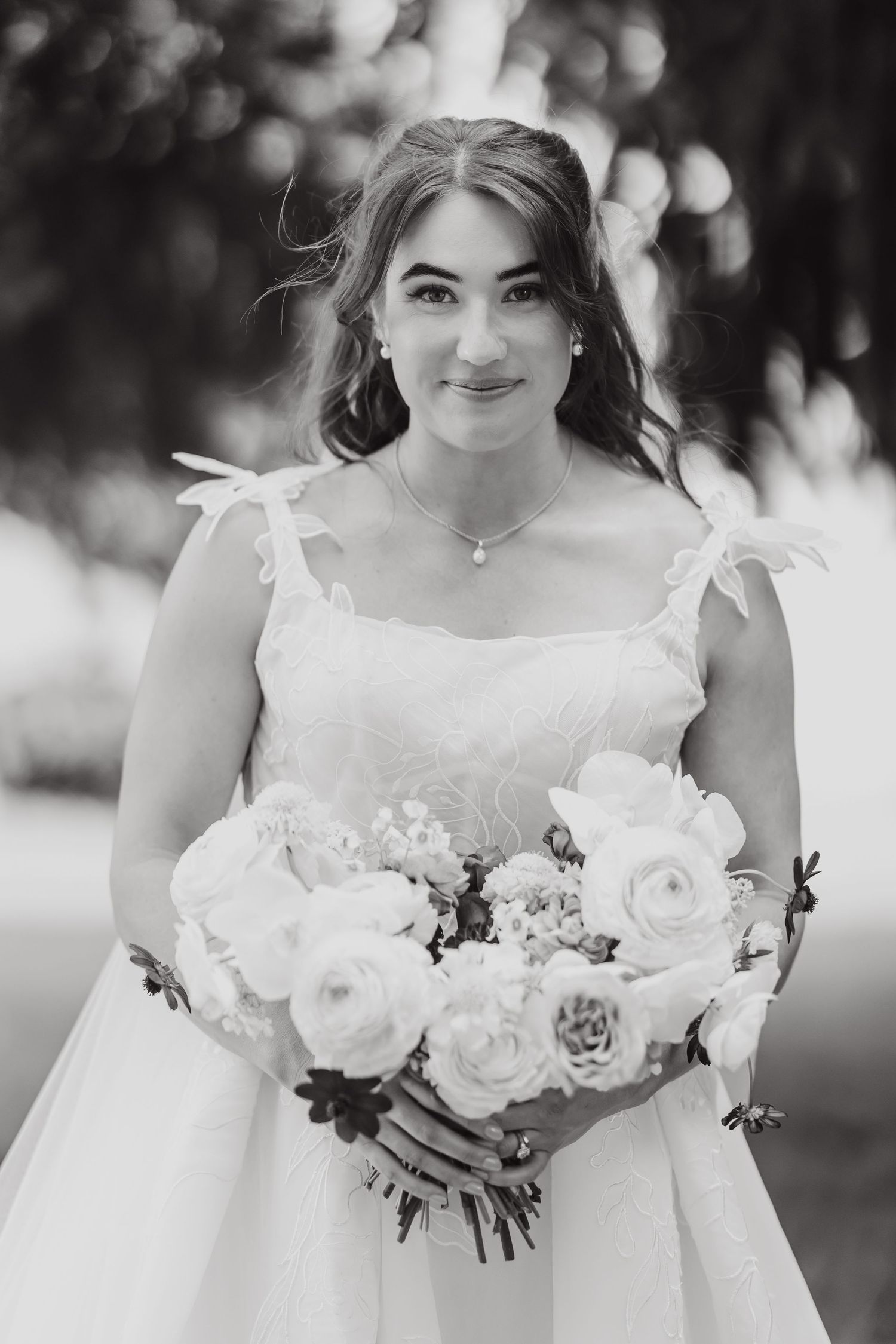 Beautiful white rose and succulent wedding bouquet held against a white dress.