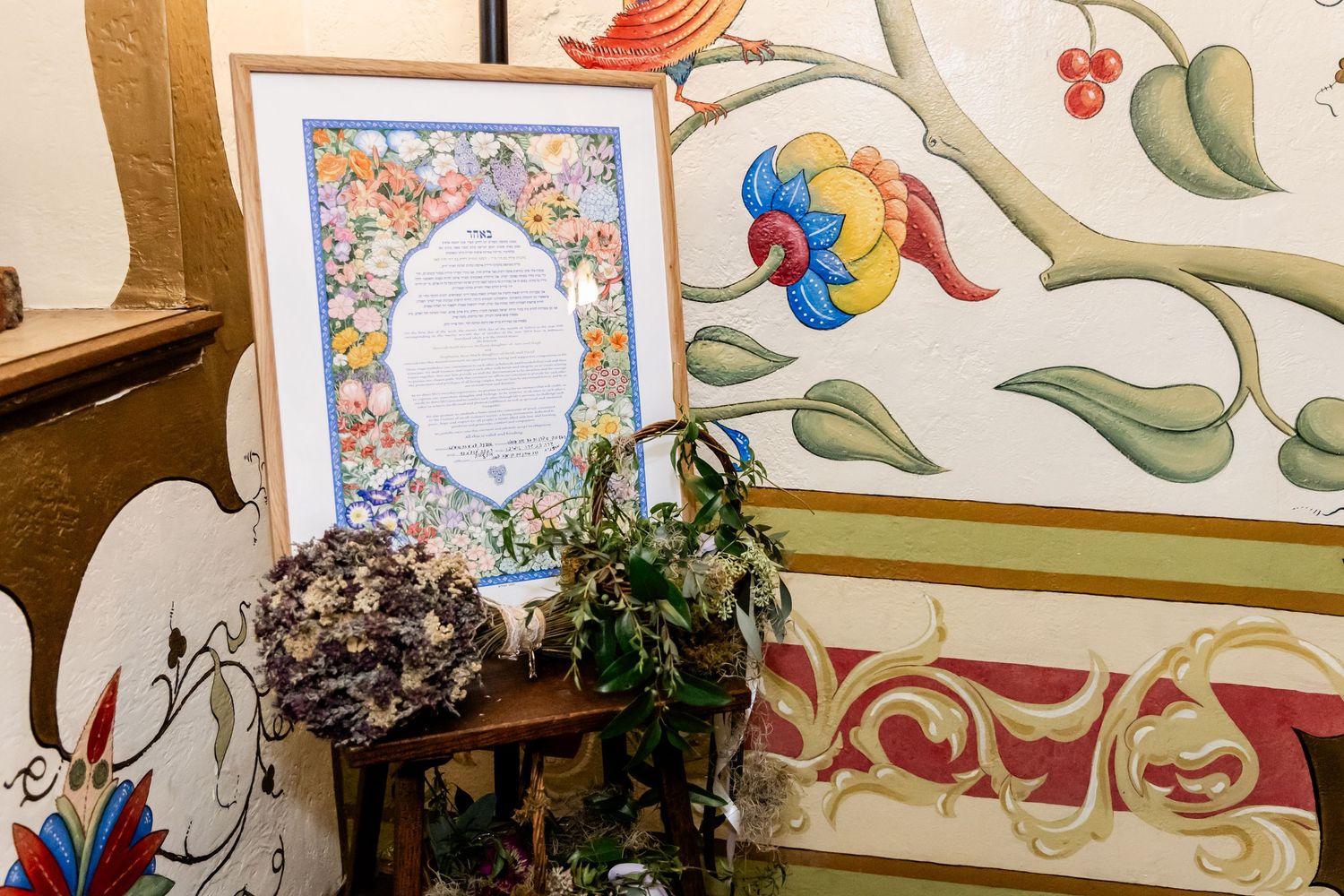 Vintage-style framed mirror with floral decorative elements and painted wall details.