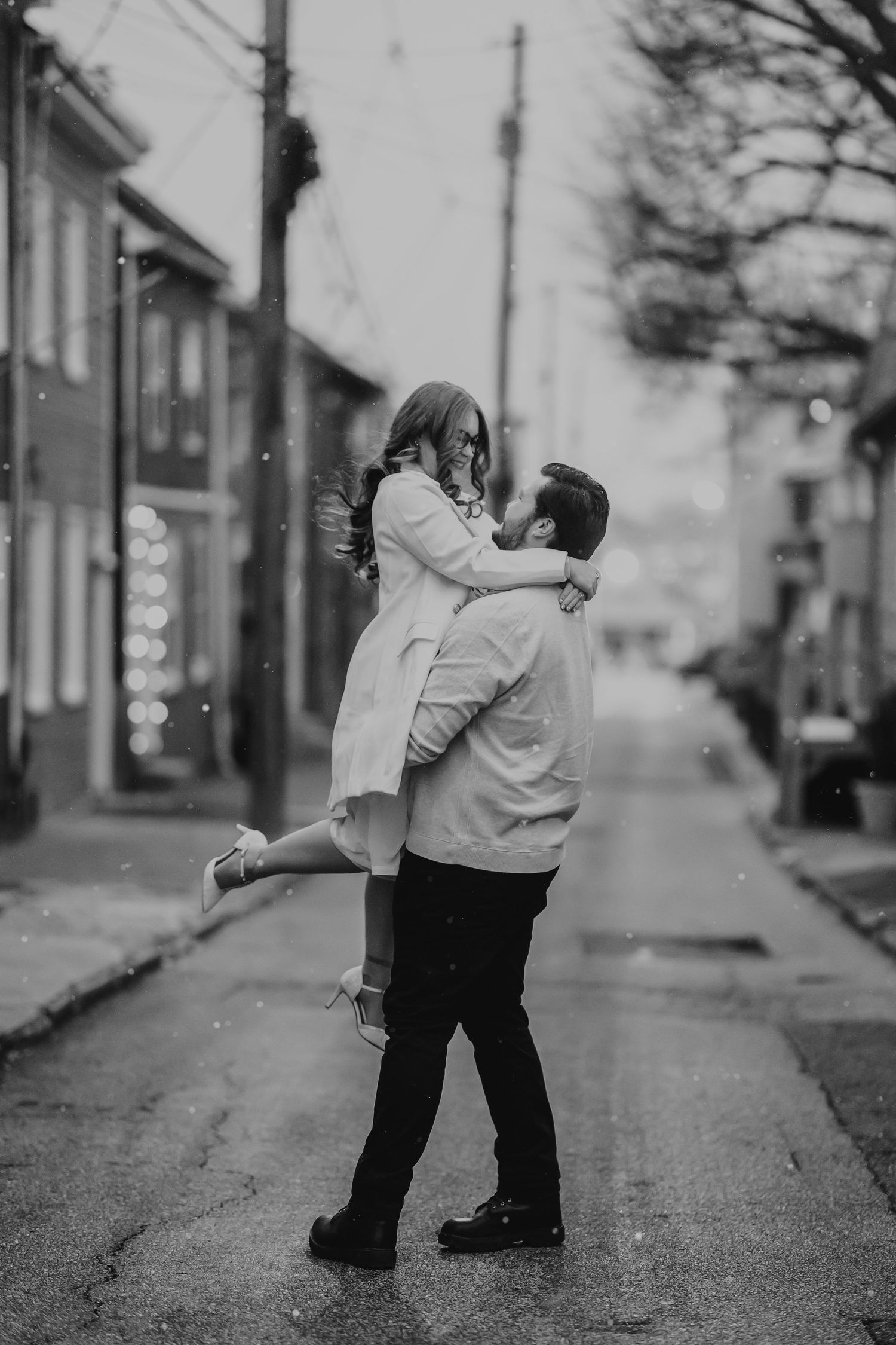 A black and white photo sequence showing two people embracing and dancing together on a quiet residential street.