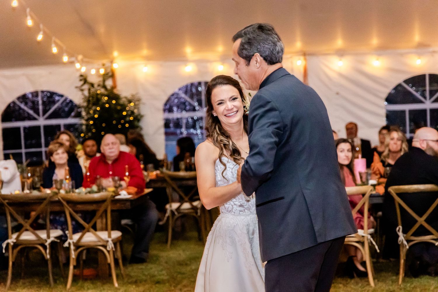 Intimate dance moments captured under string lights at an outdoor tent reception.