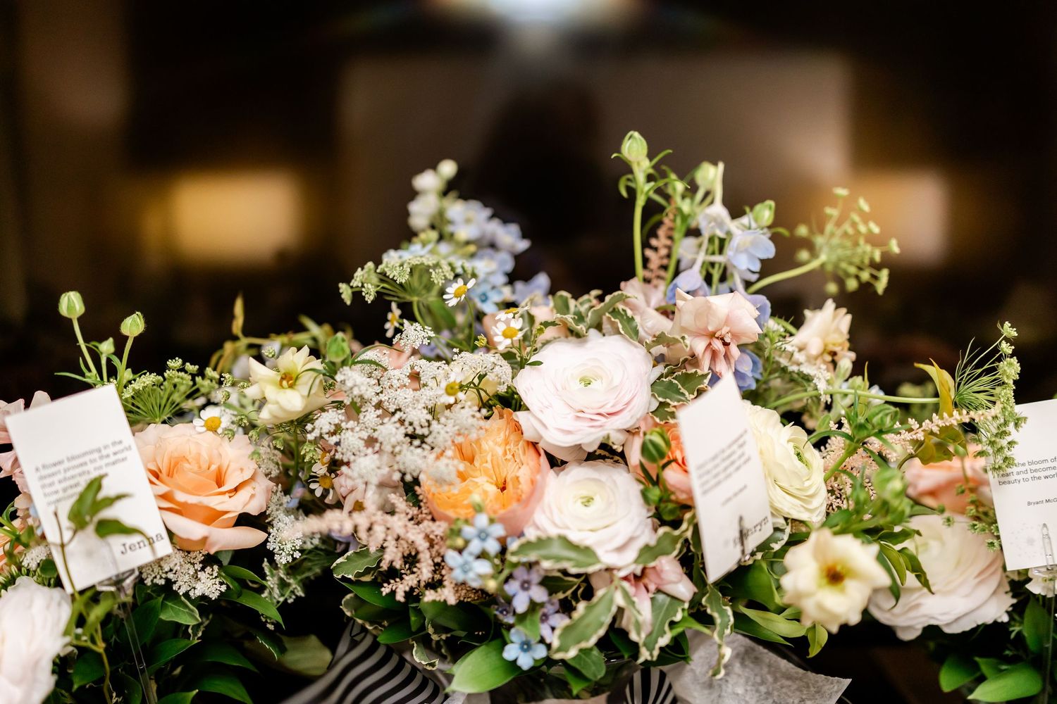 Elegant floral wedding centerpieces with white and pink flowers arranged along a decorated table.