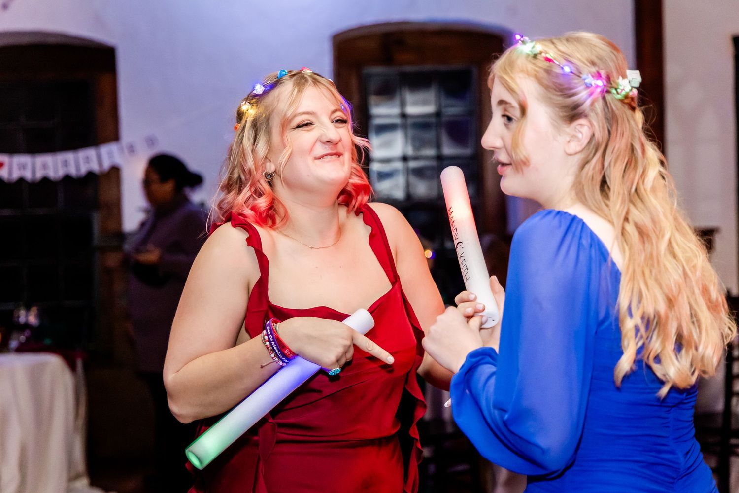 People dancing and enjoying themselves at a formal celebration with colorful lighting.