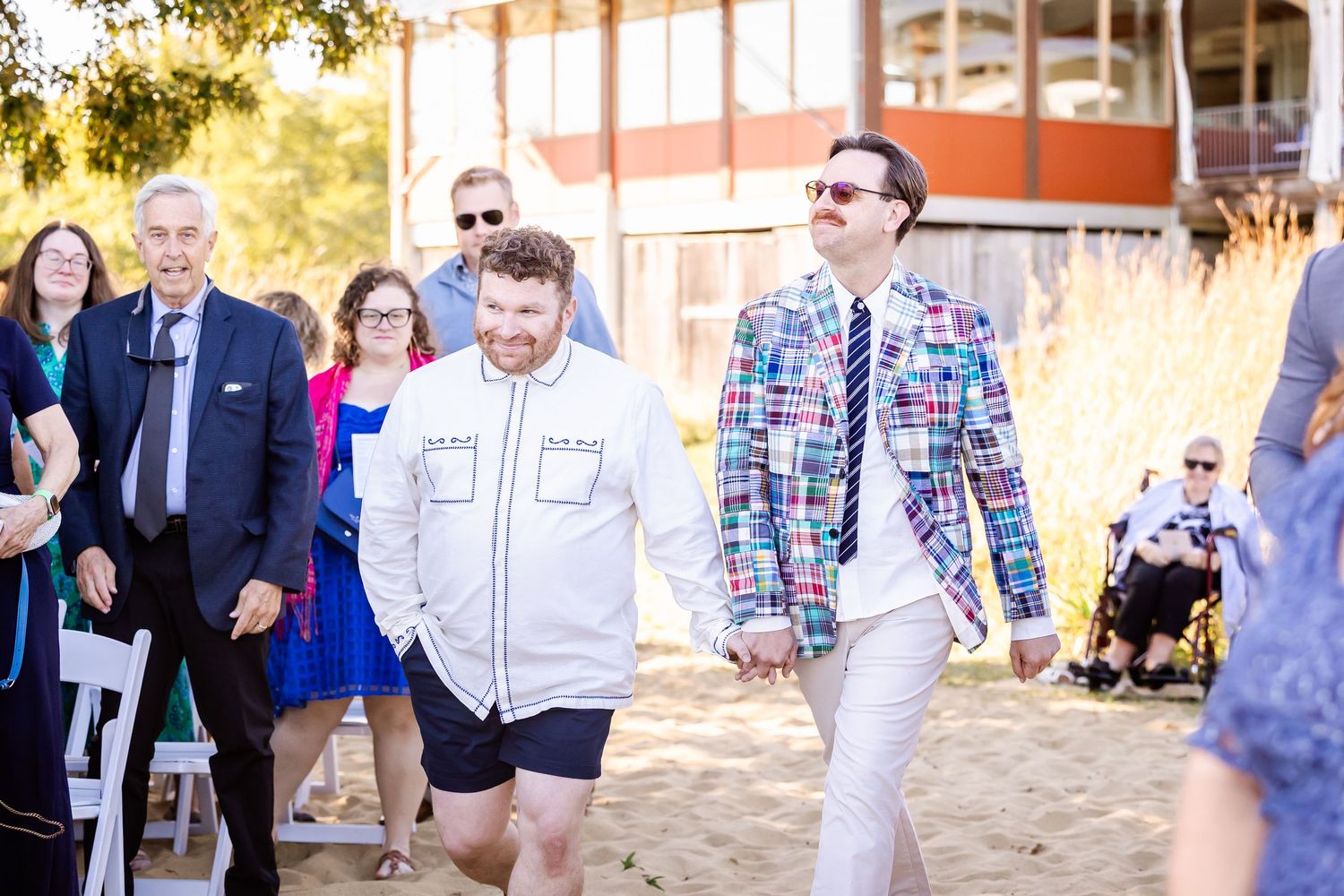 A group of people walking and socializing outdoors during a sunny day event.
