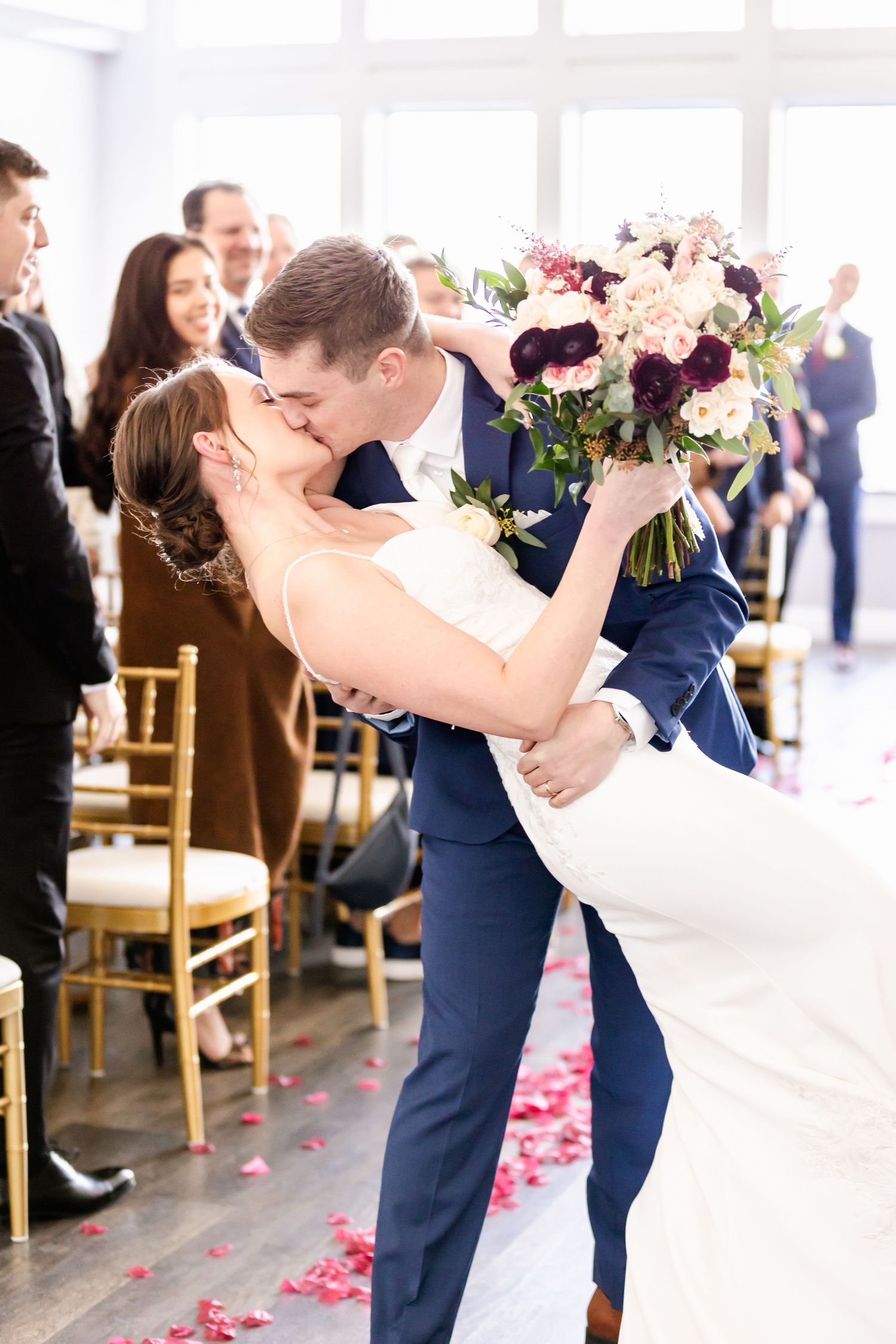 Romantic first dance moment at indoor wedding reception with guests watching.