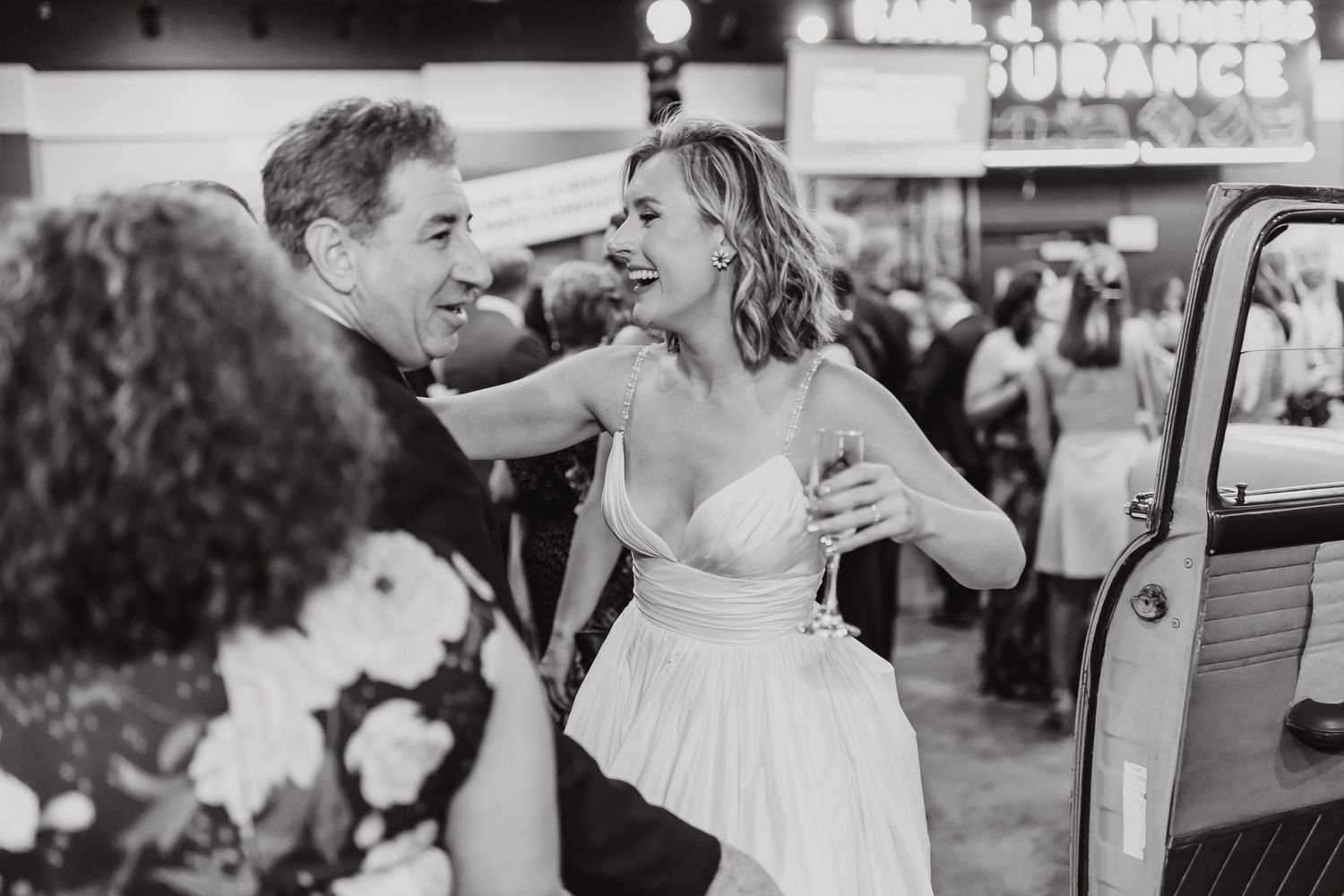 A candid black and white moment of joy captured during wedding celebrations.