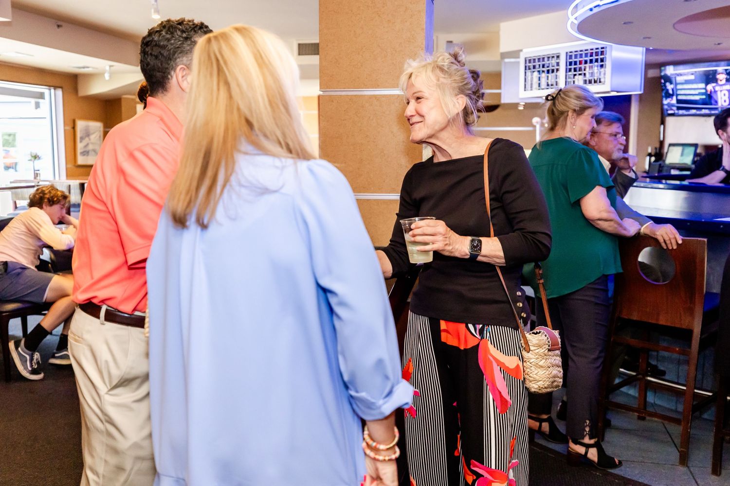 Guests mingling and socializing at a casual indoor bar event.