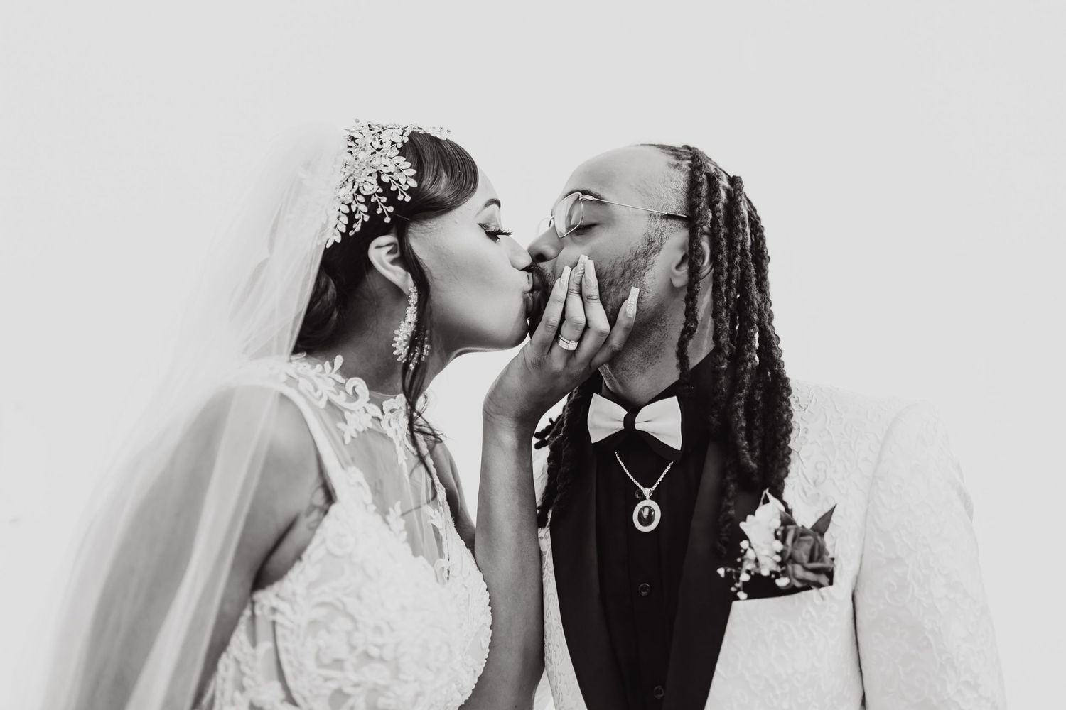 Black and white portrait of newlyweds sharing a romantic kiss.