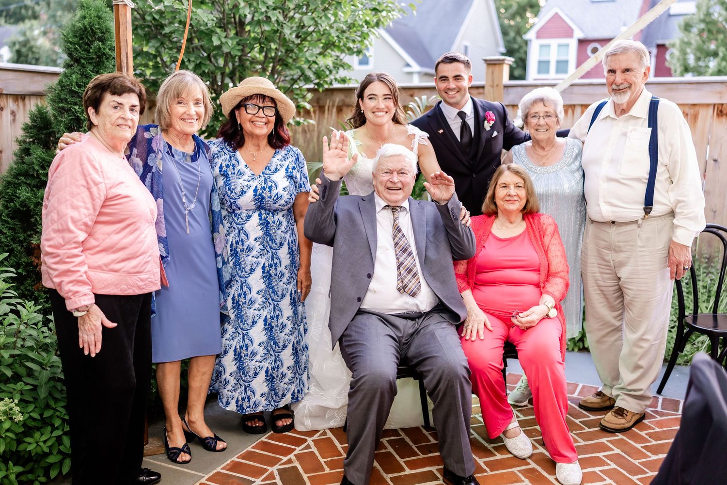 Wedding guests gathered for group photos in a garden setting.