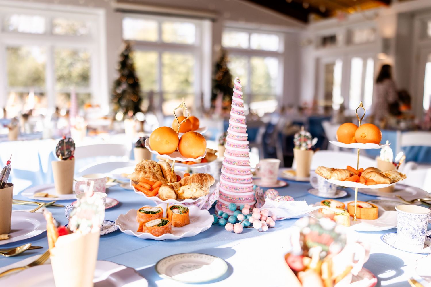 Festive table settings with orange decorations and party favors at an elegant celebration.