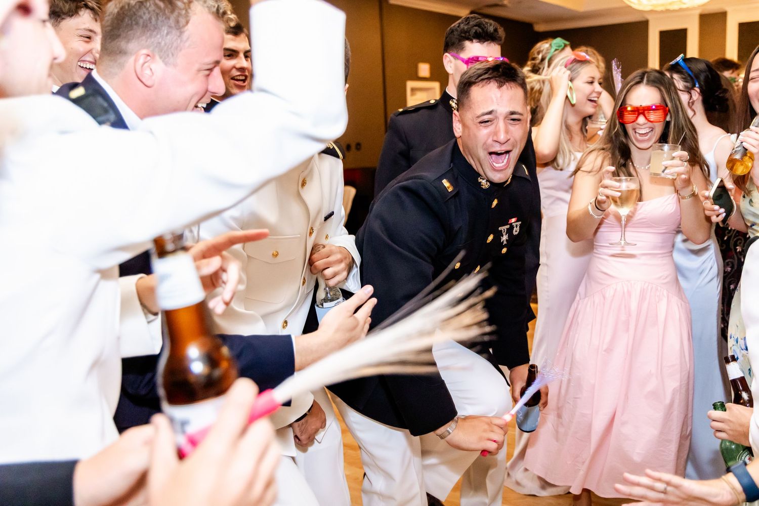 Energetic crowd of wedding guests dancing and celebrating on a packed dance floor.