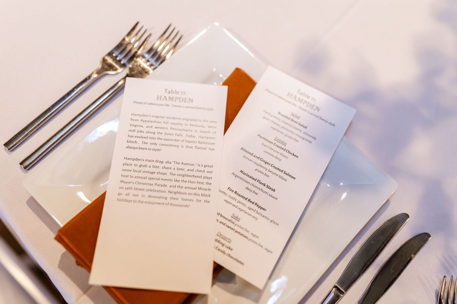 Wedding reception place setting with menu cards and silverware.
