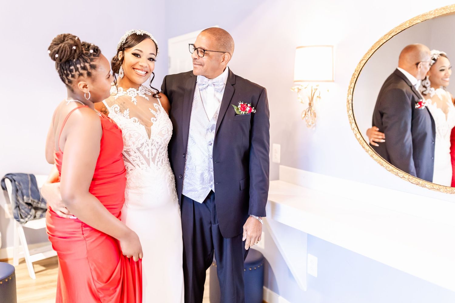 Wedding party members share a joyful moment together in formal attire against a white backdrop.