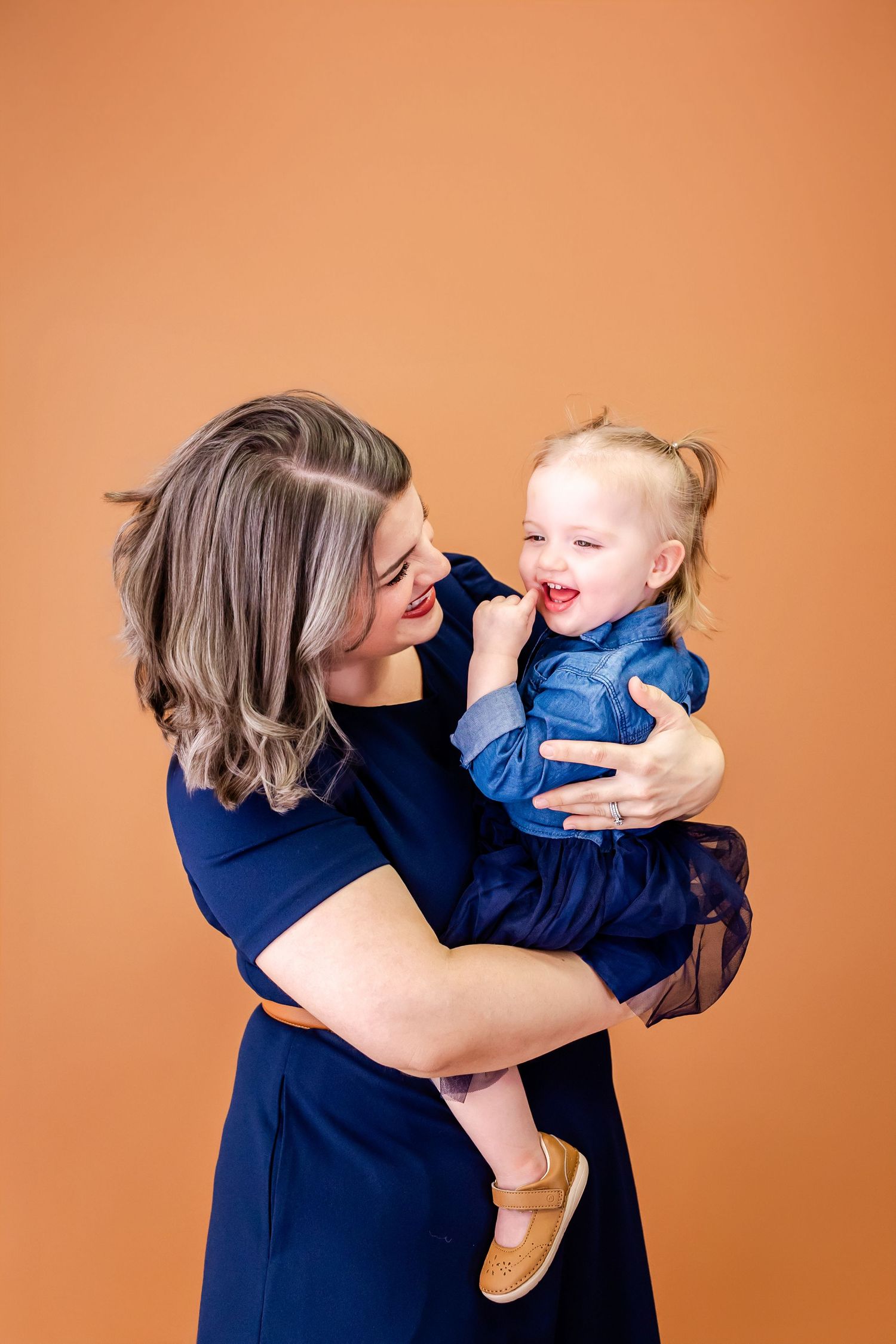 Heartwarming series of interactions between parent and child in navy blue against orange background.