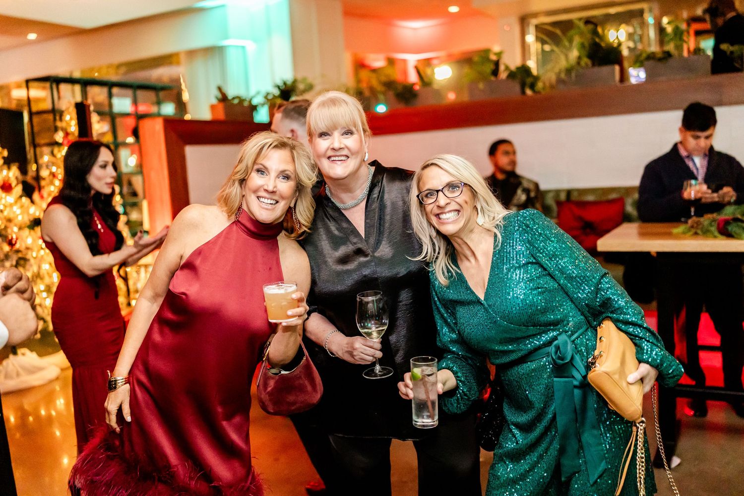 Guests enjoying a holiday party with colorful lighting and festive decorations.