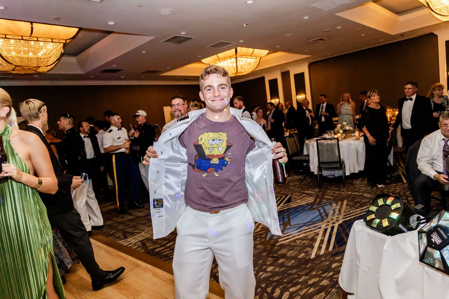 Wedding reception celebration with guests dancing and mingling in a luxurious hotel ballroom.