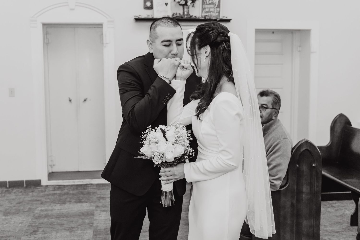 An emotional black and white wedding ceremony moment shared between a couple.