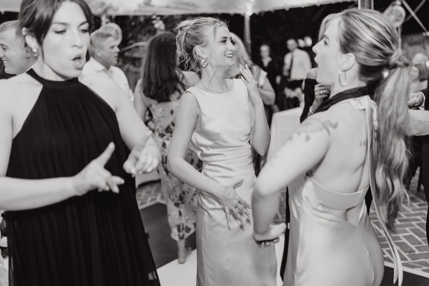 Guests enjoying themselves on a crowded dance floor during a wedding celebration.