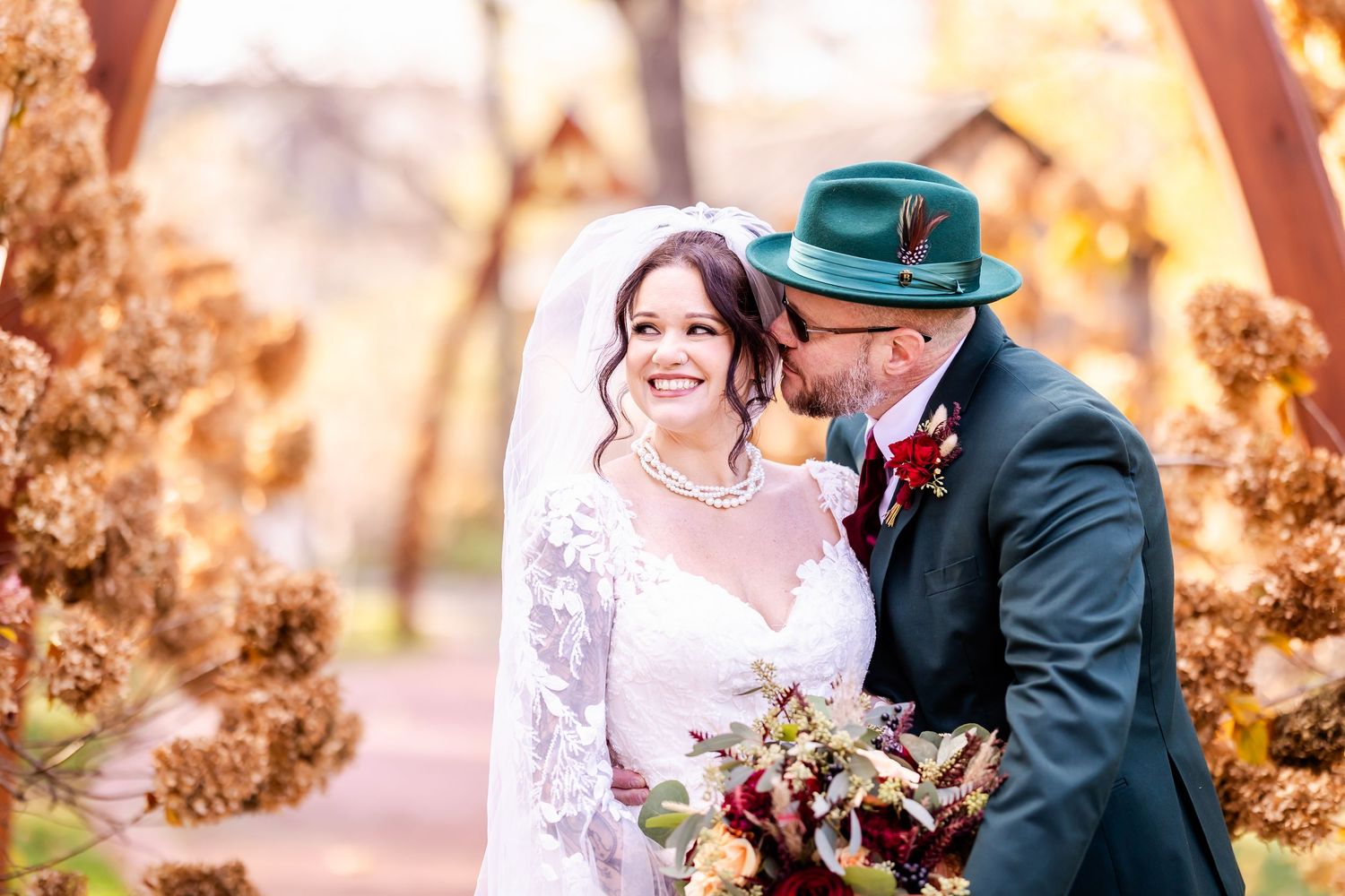 Romantic autumn wedding scene with golden sunlight filtering through trees.