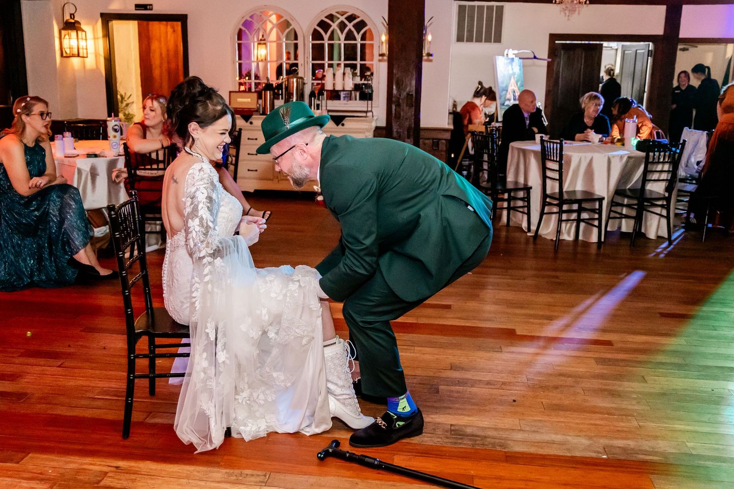 A wedding tradition moment as someone retrieves a garter from beneath the bride's dress at the reception.