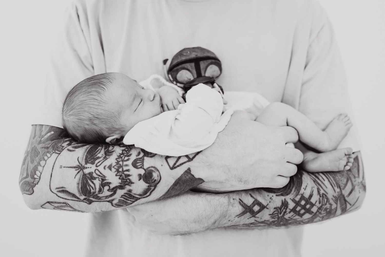 Black and white photographs show a sleeping infant wrapped in white blankets in different positions and angles.