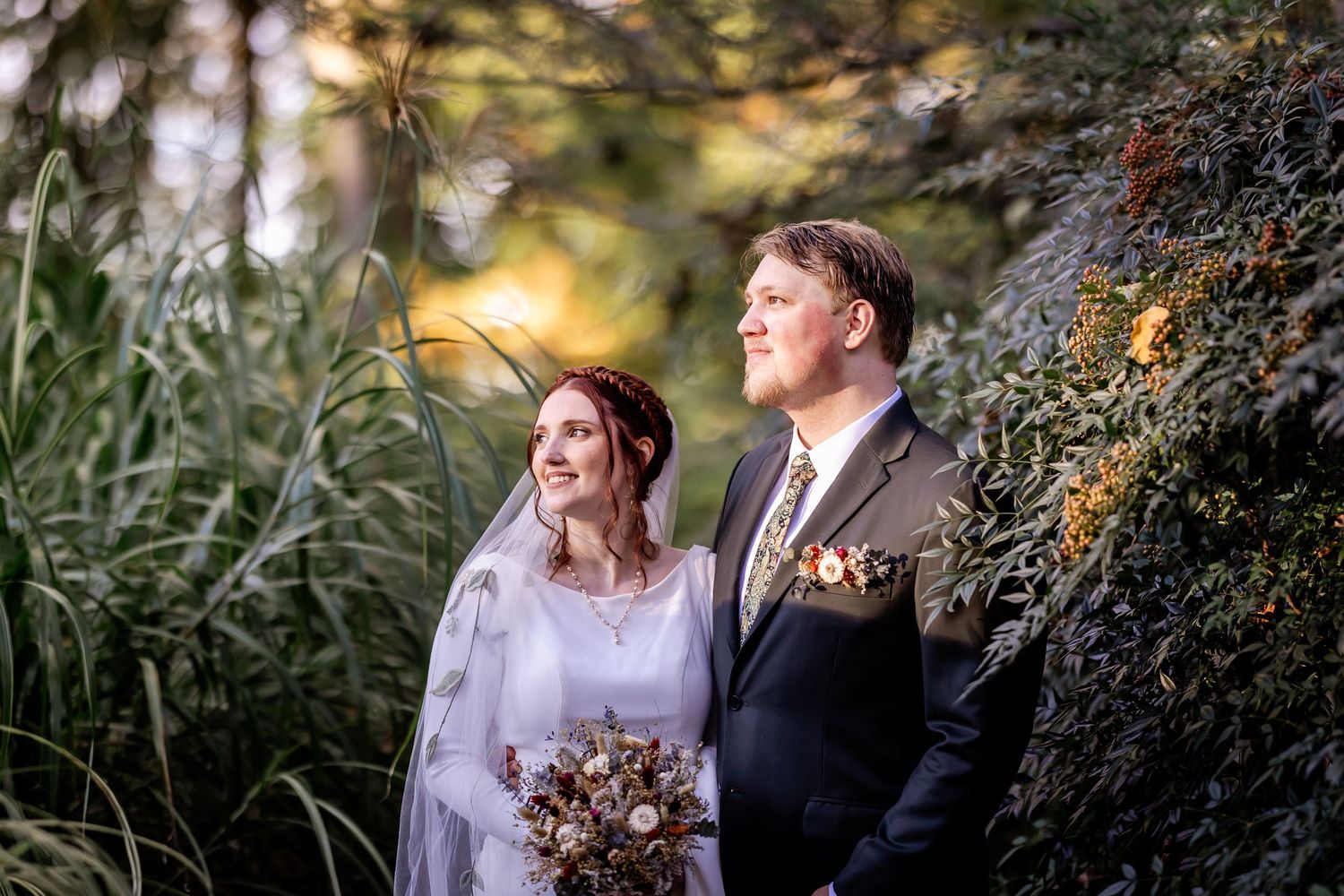 A couple shares an intimate moment under autumn trees during their outdoor wedding photoshoot.