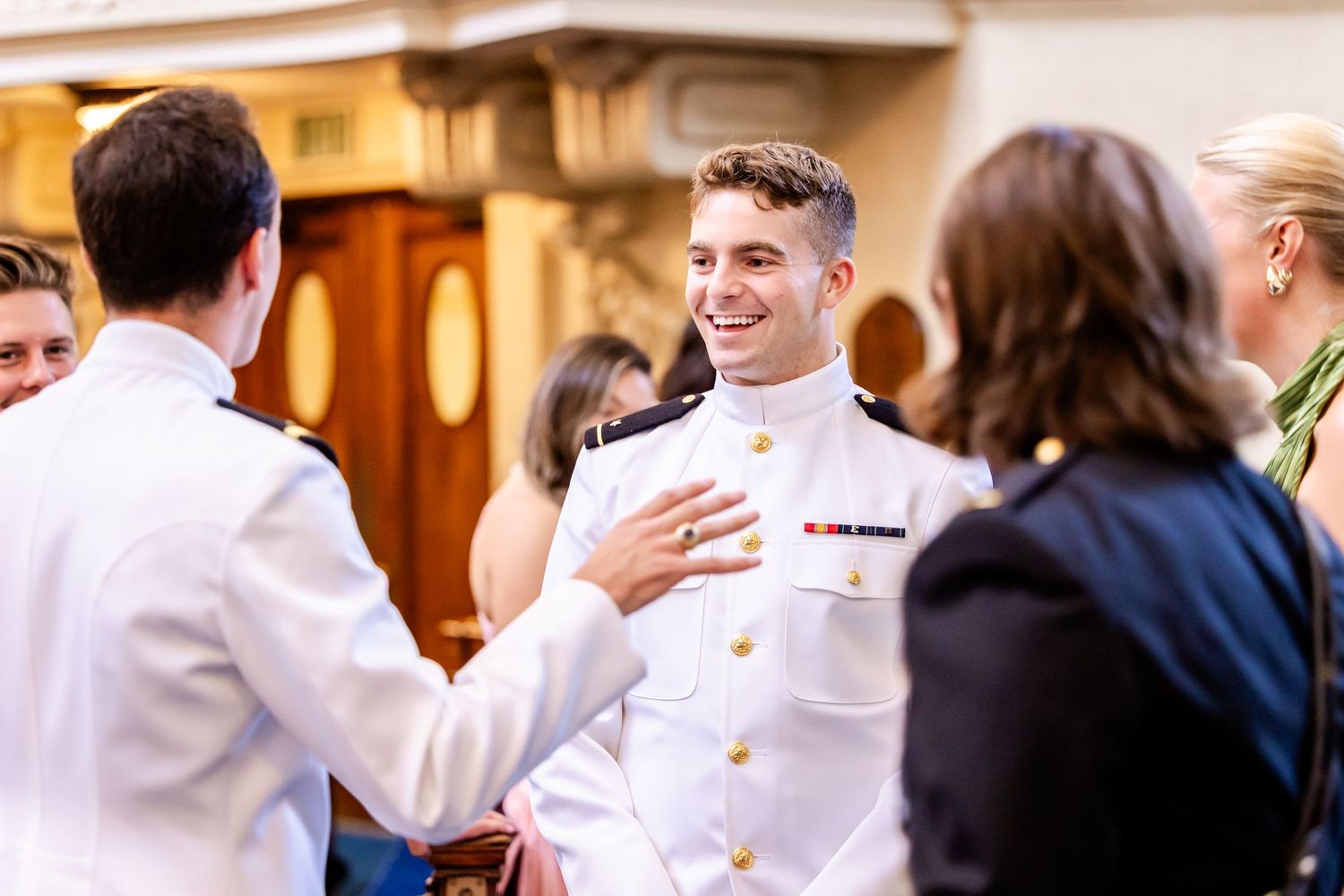Wedding reception guests mingling and socializing in formal attire.
