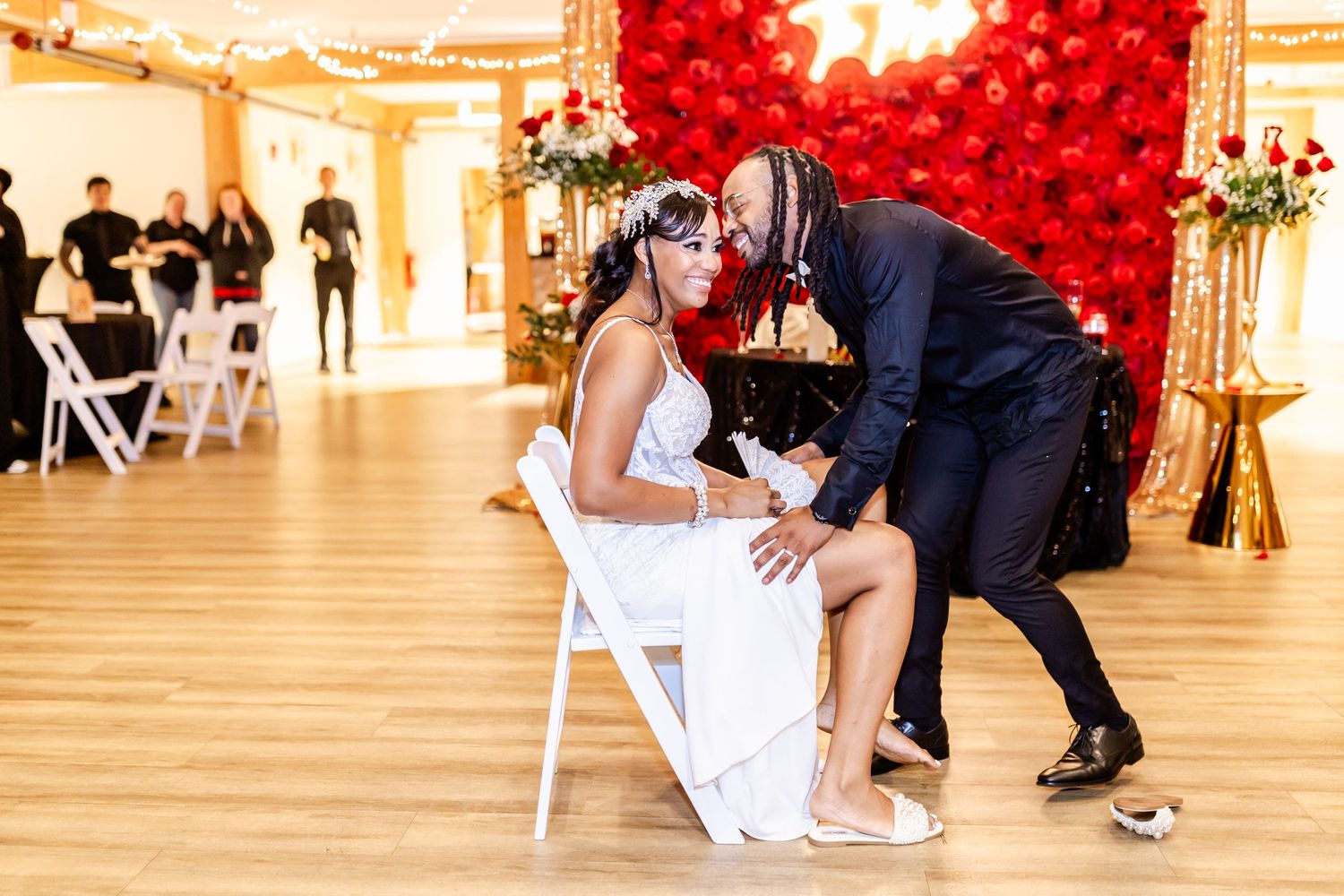 Wedding celebration moment in an elegant ballroom with red balloon decor.
