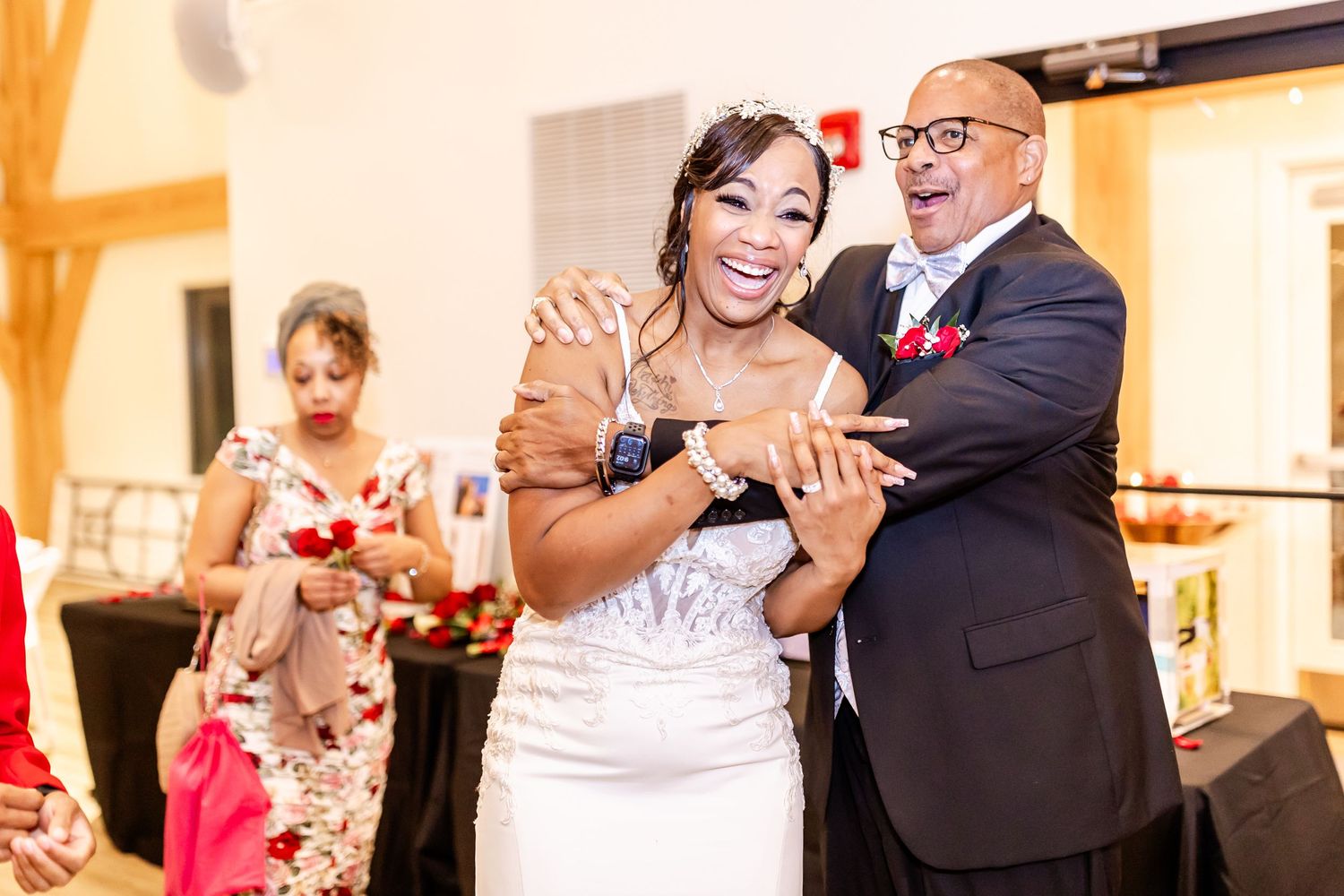 Couple dancing together at an indoor wedding celebration with warm lighting.