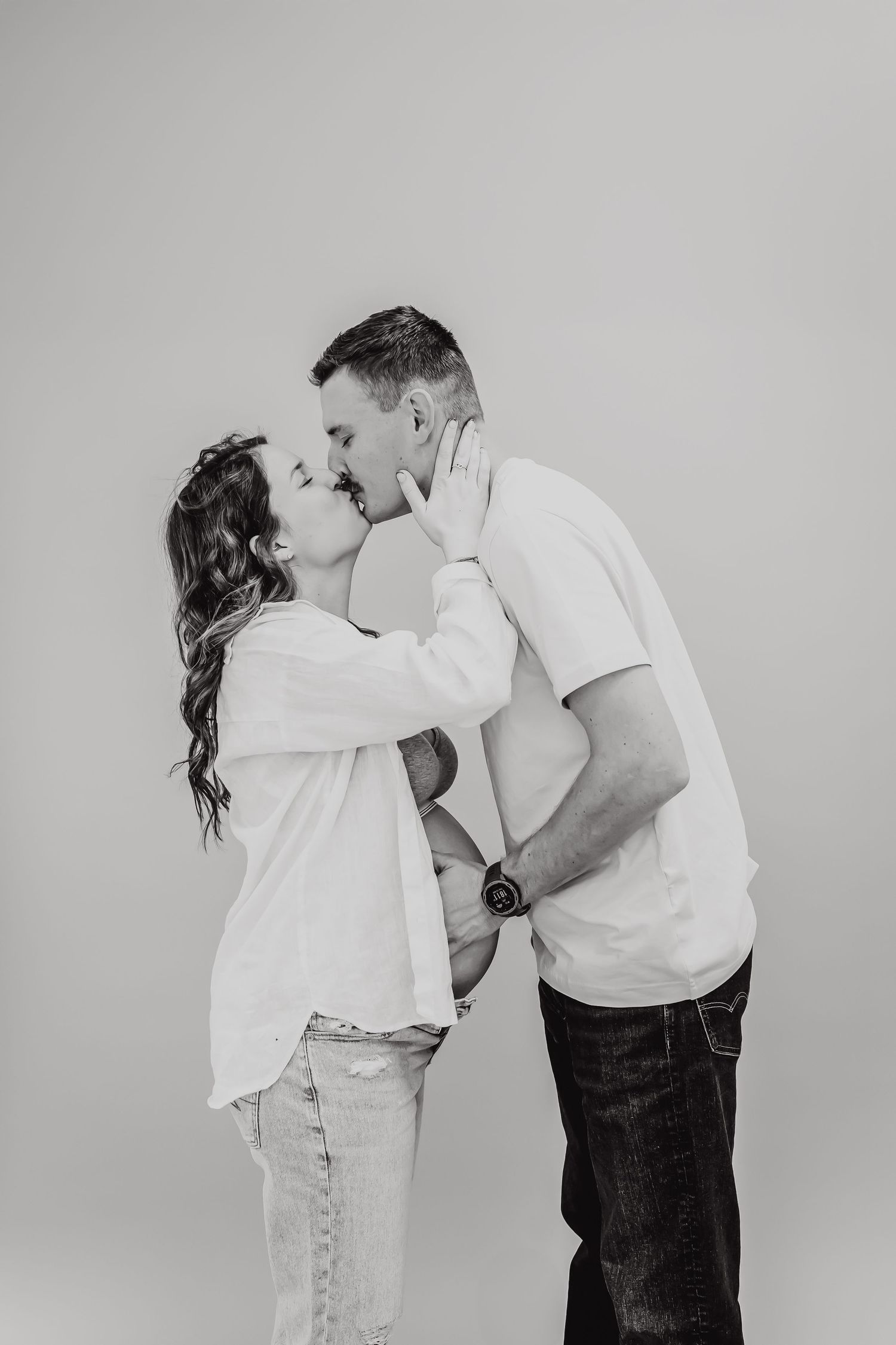 Black and white intimate portrait of couple in casual attire sharing a tender moment.