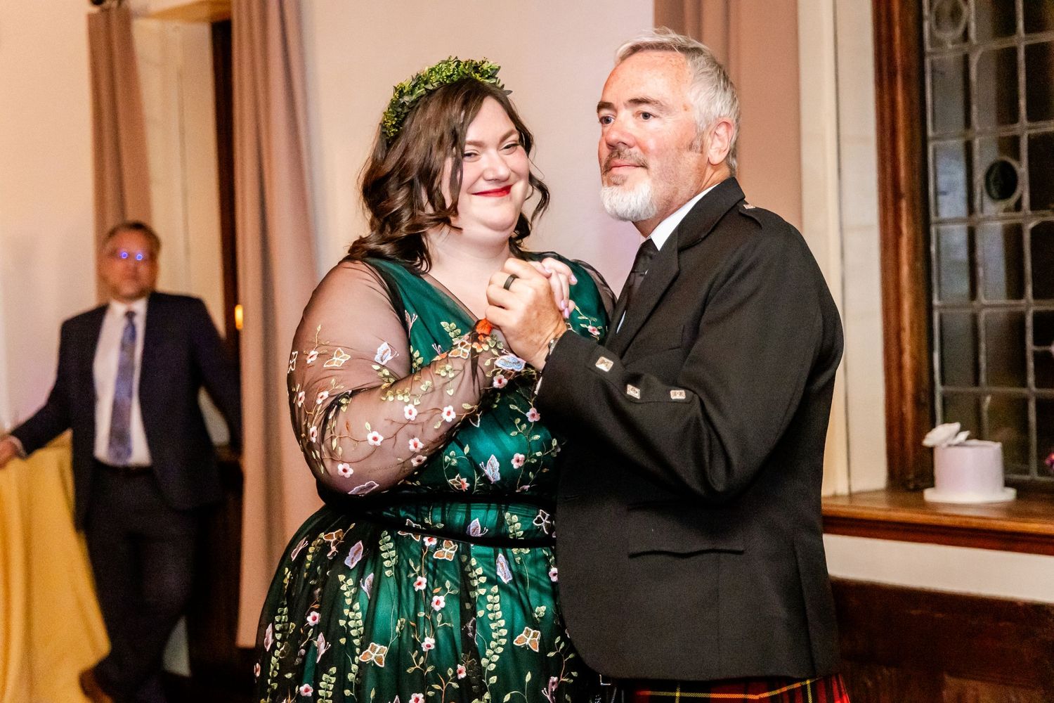 Wedding guests dancing during reception celebration in an elegant indoor venue.