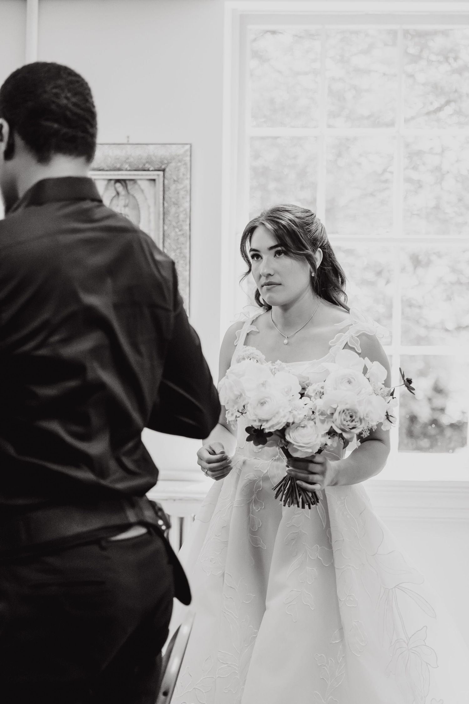 Black and white wedding photos show bride holding elegant white rose bouquet.