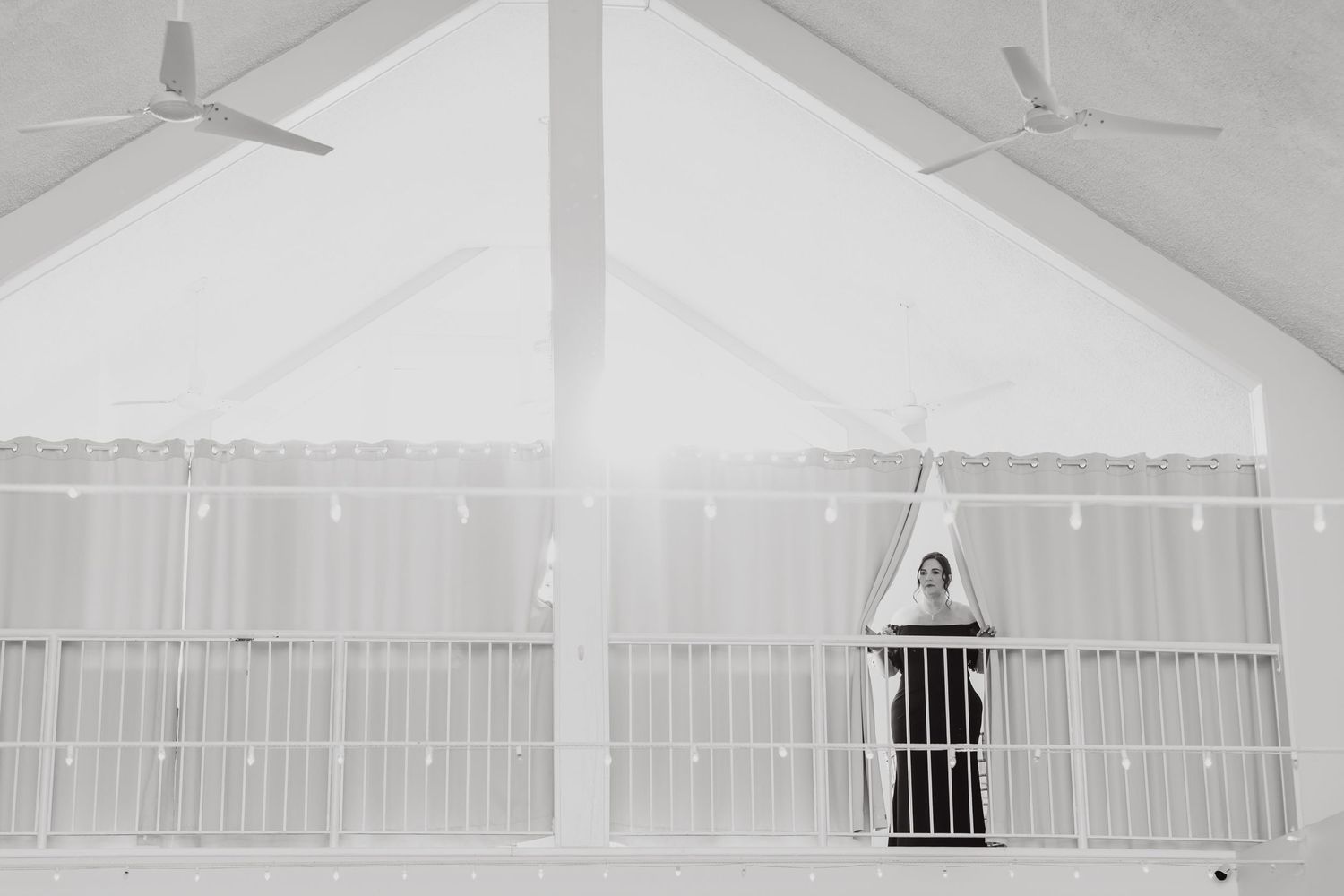 Black and white photos showing figures walking along an elevated indoor balcony or walkway.