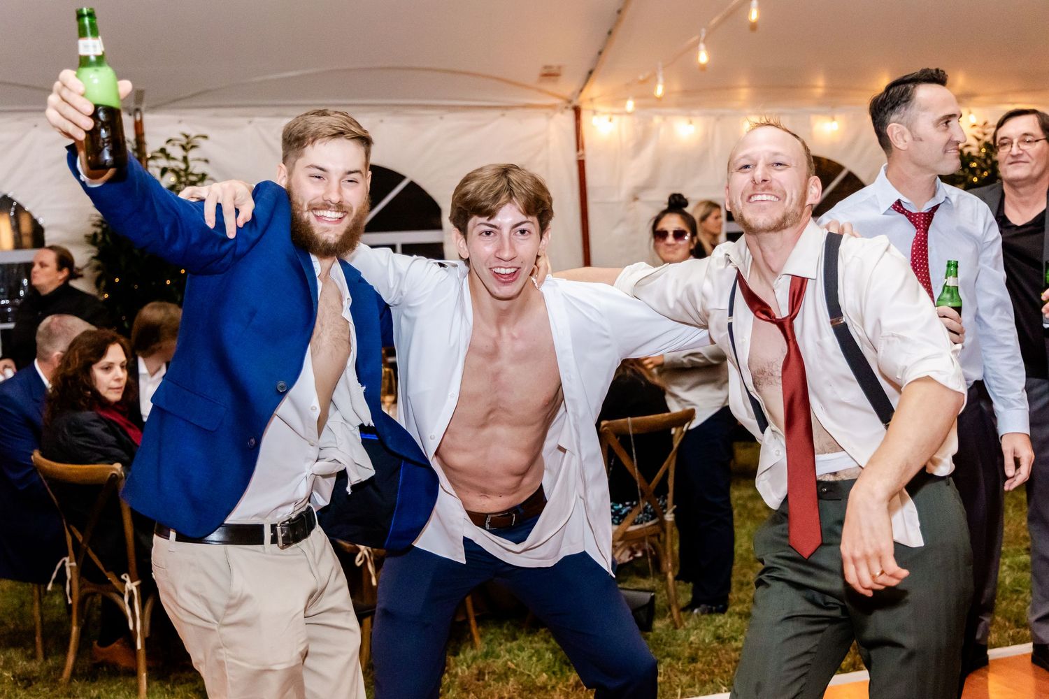 Energetic dance floor moments captured at a wedding reception with guests in formal attire.