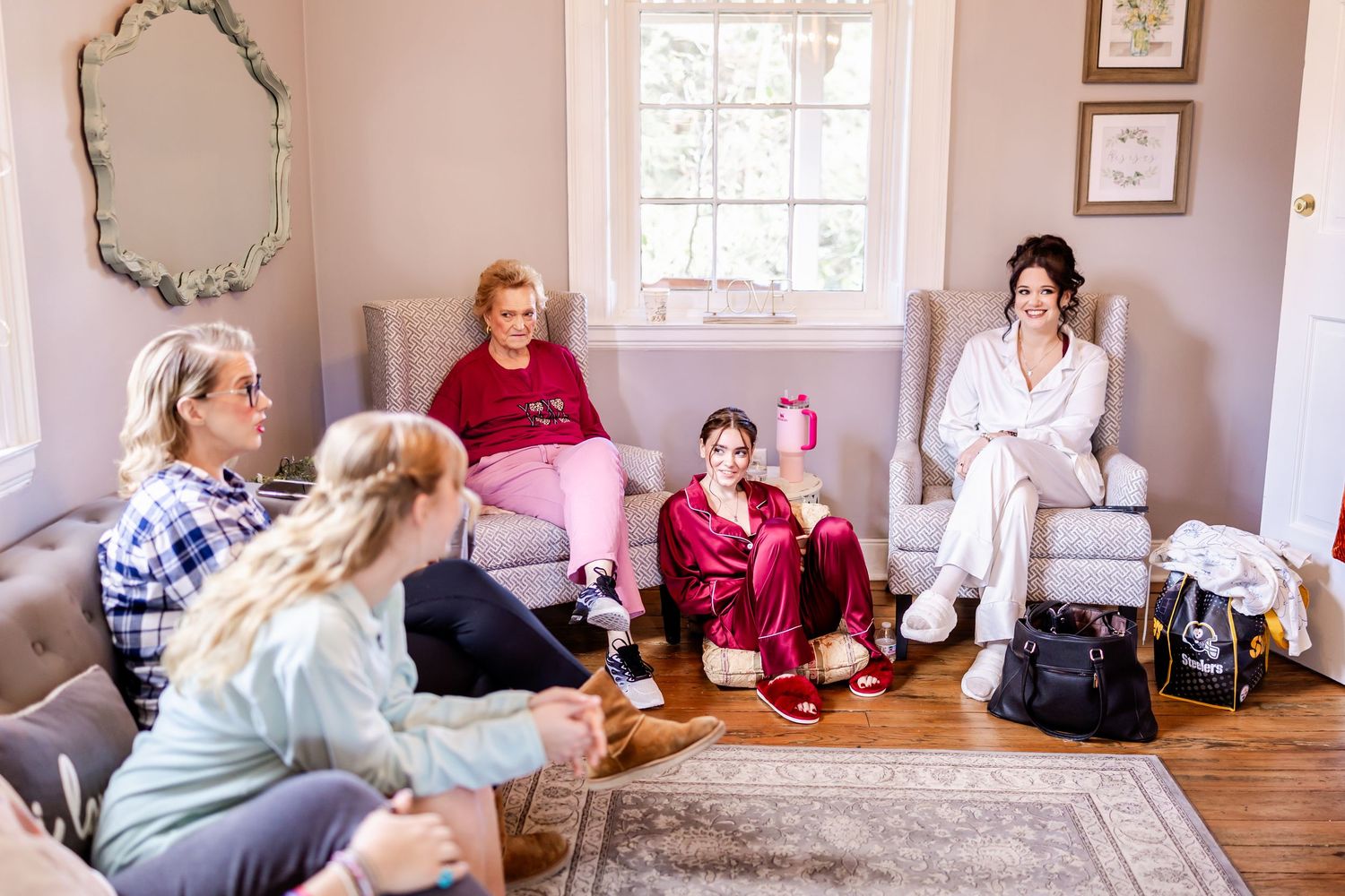 Group gathered in a bright room with pink walls for a casual social gathering around a table.