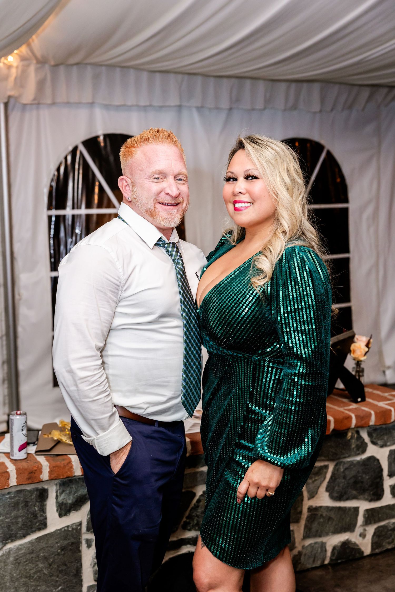 Couple dancing and celebrating at wedding reception in white tent venue.