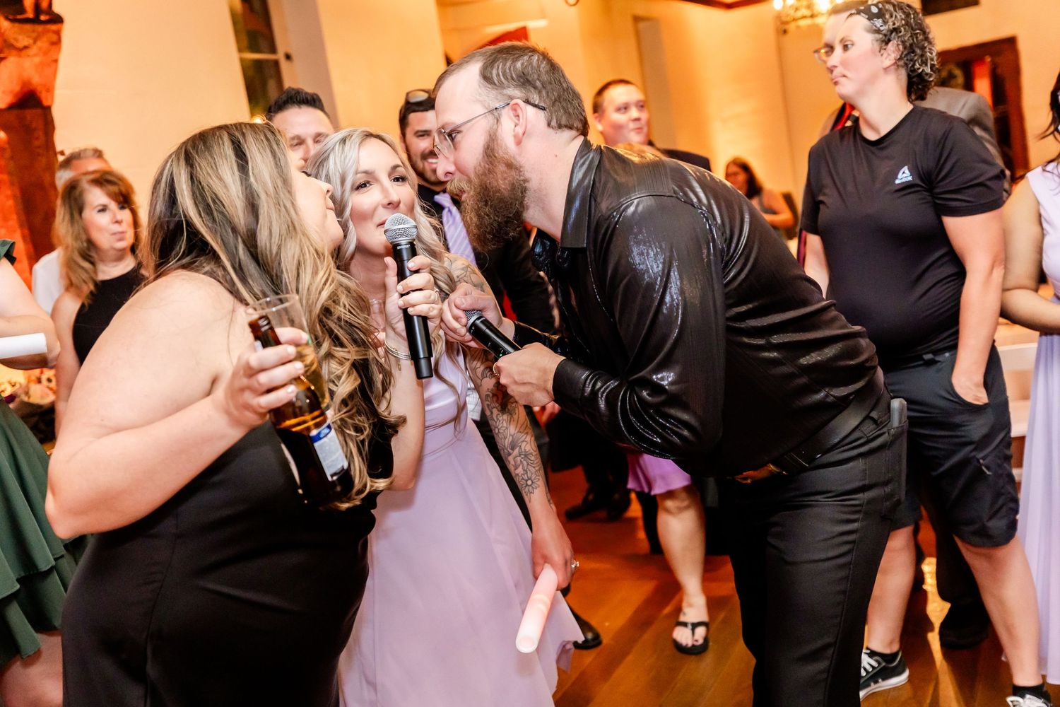 Guests singing into microphones during an animated party performance.