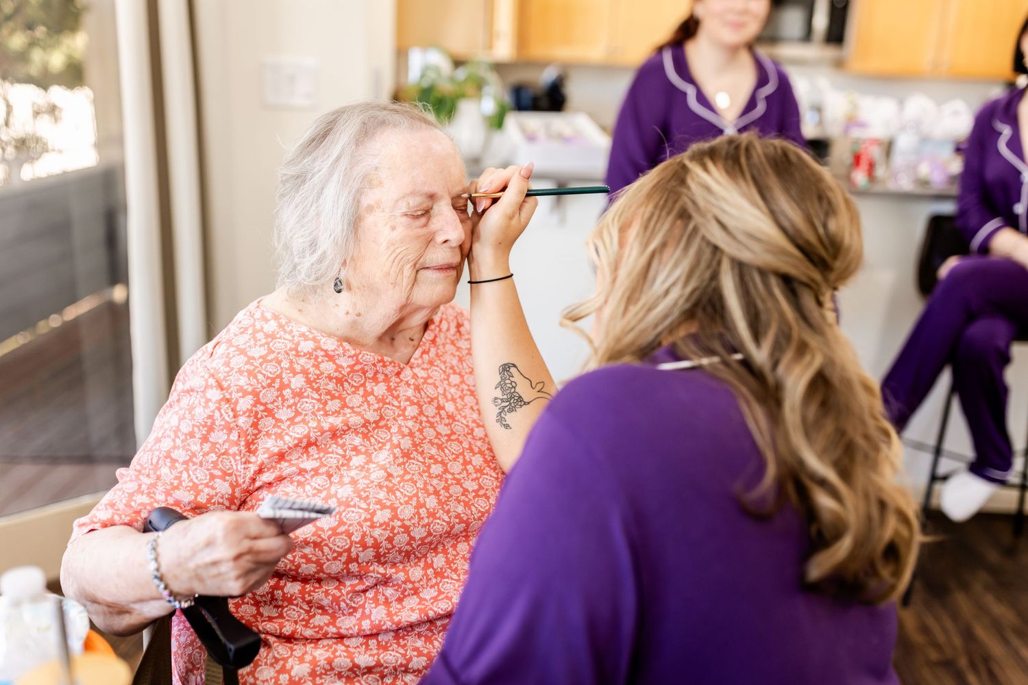 Person in purple uniform providing beauty services in a home setting.