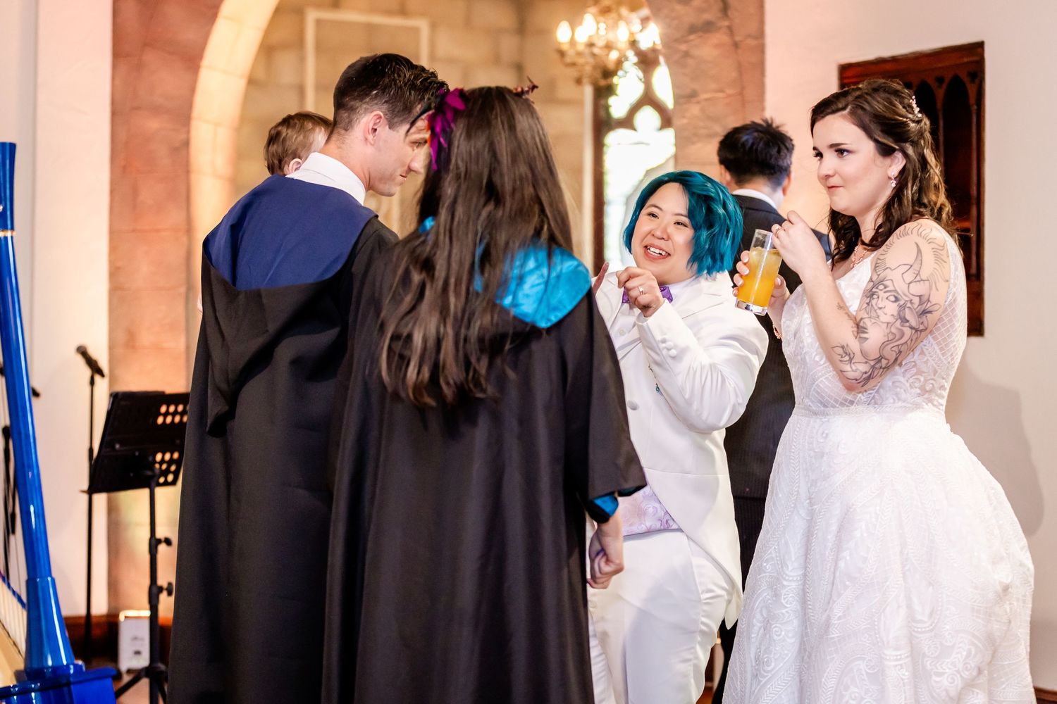 Group celebrating joyfully during indoor wedding ceremony.