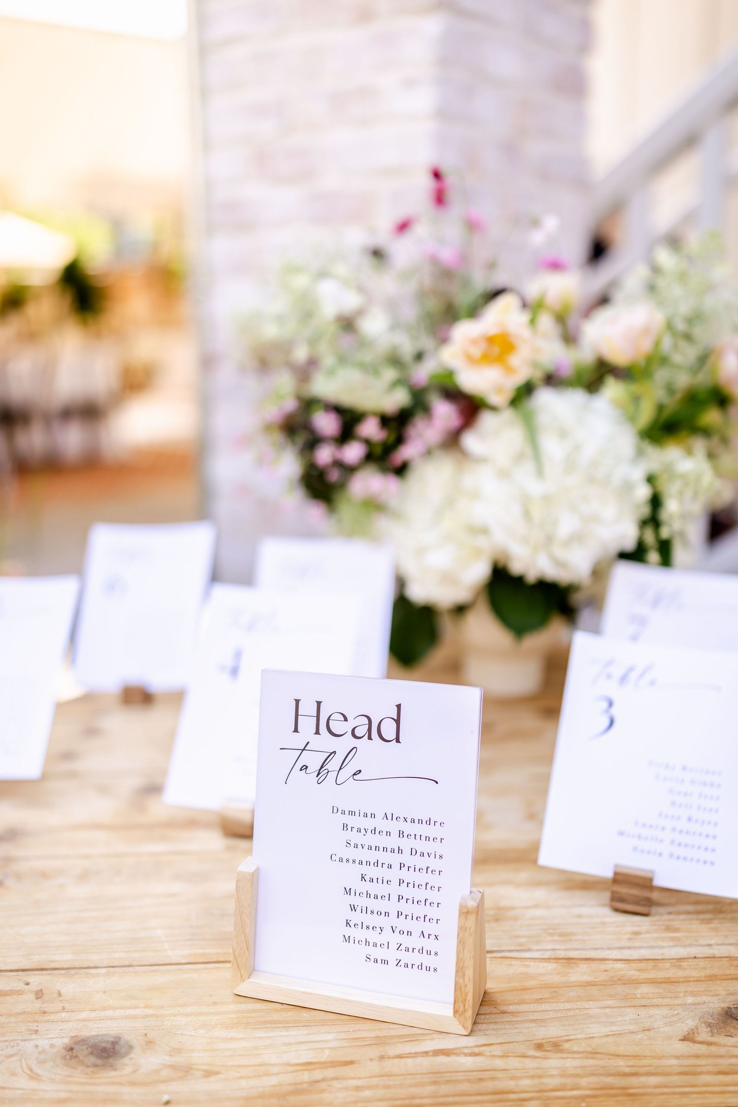 Wedding reception place cards and table numbers displayed with delicate floral arrangements.