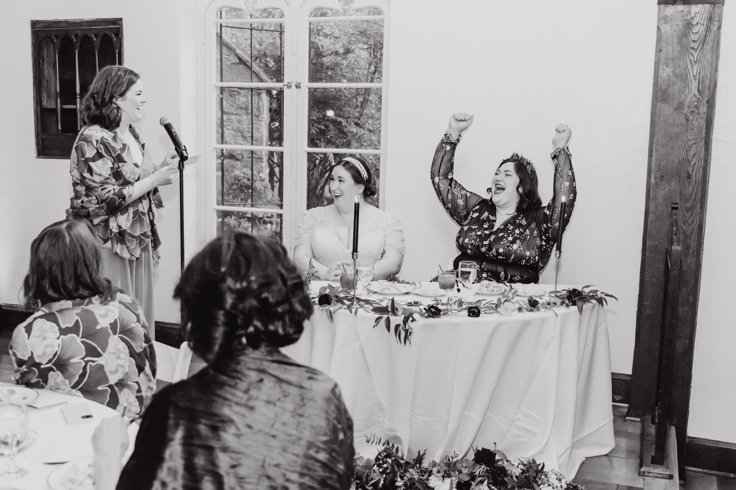 Black and white photo of wedding reception toasts and celebrations.
